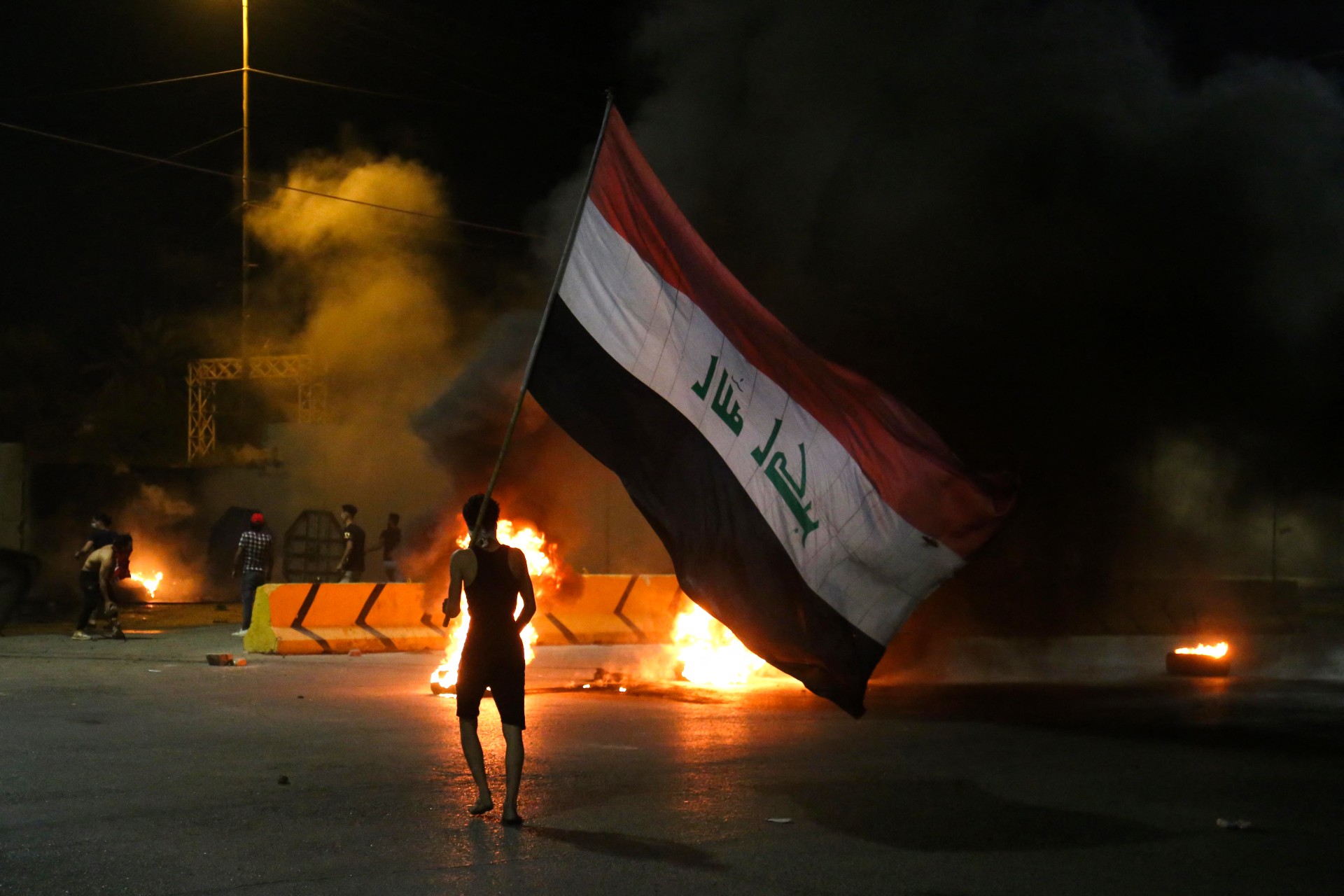Iraqi protesters burn tyres in front of the Karbala governorate headquarters (AFP)