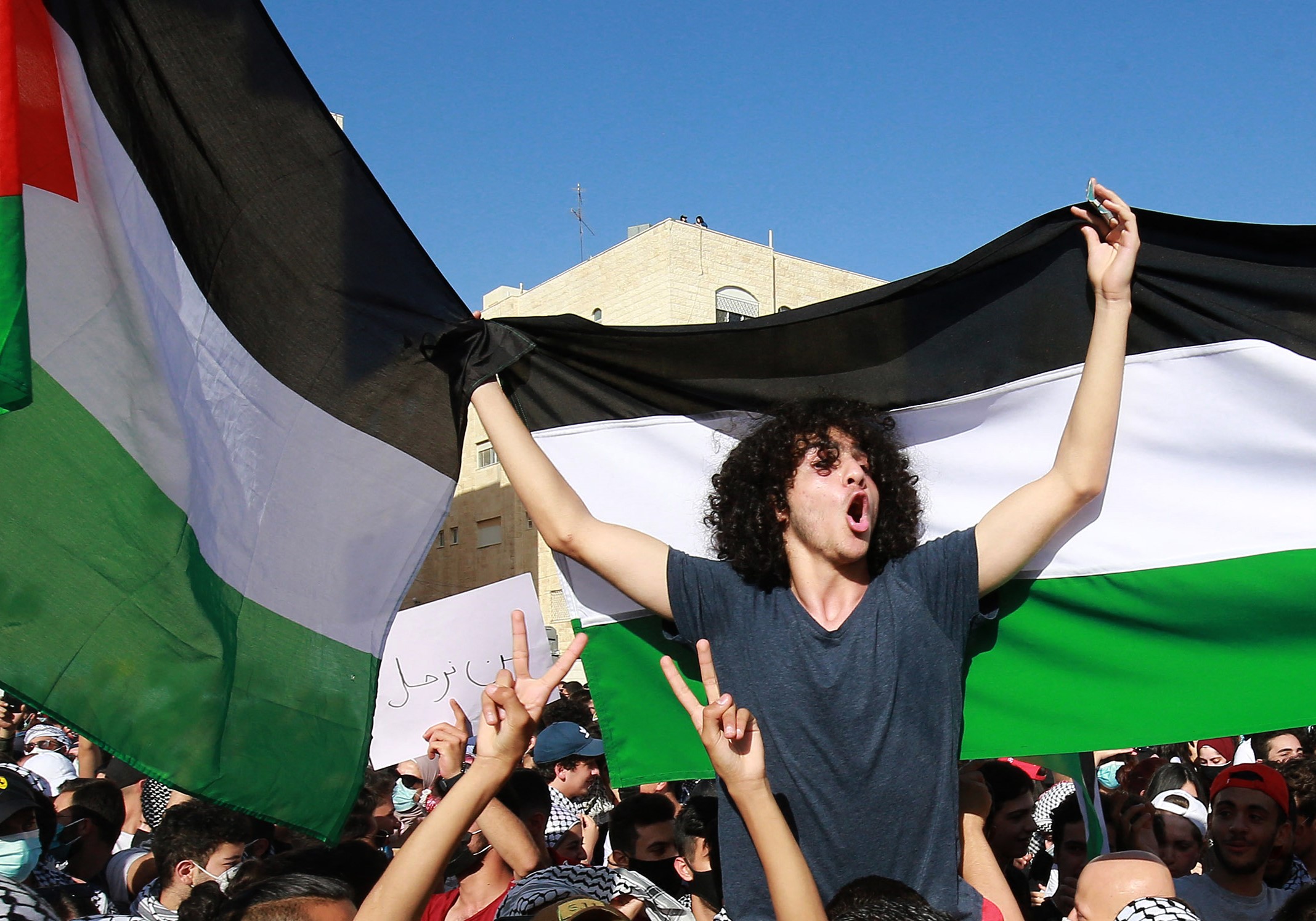 Protesters chant slogans and wave Palestinian flags as they gather for a demonstration in solidarity with the Palestinian people near the Israeli embassy in Jordan's capital Amman on May 11, 2021.