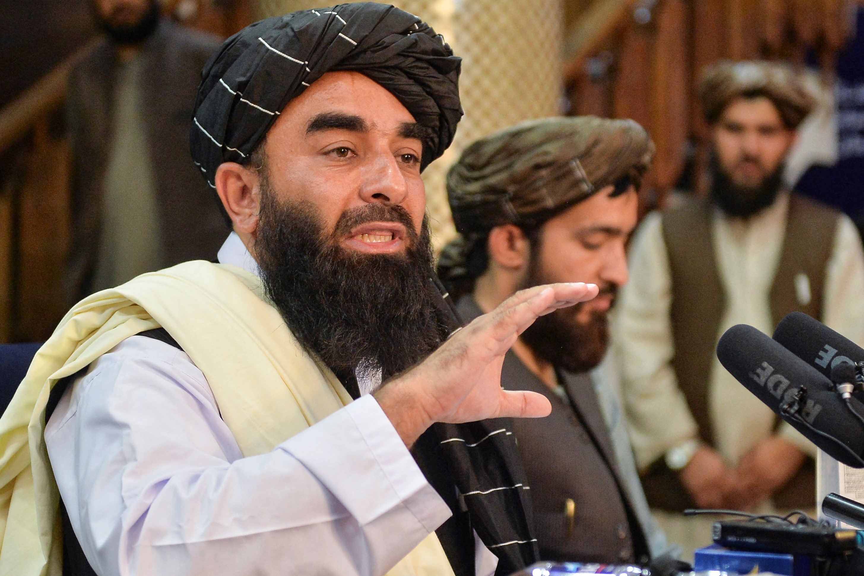Taliban spokesperson Zabihullah Mujahid (L) during the first press conference in Kabul on 17 August, 2021 (AFP)