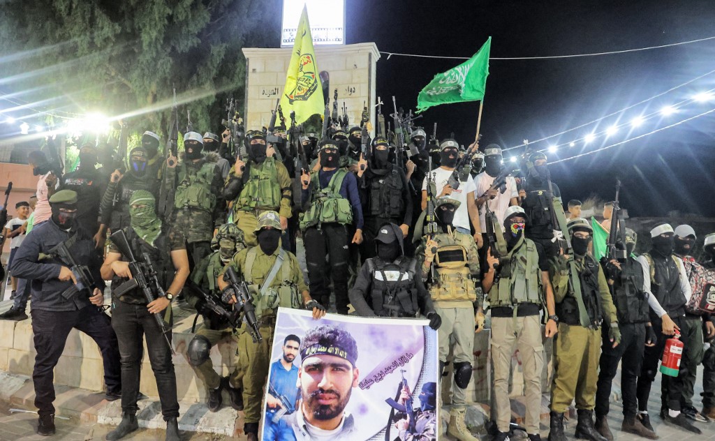 Gunmen belonging to military wings of Fatah, Hamas and Islamic Jihad pose for a group photo at a square in the Jenin camp in 18 August 2021. (Afp)