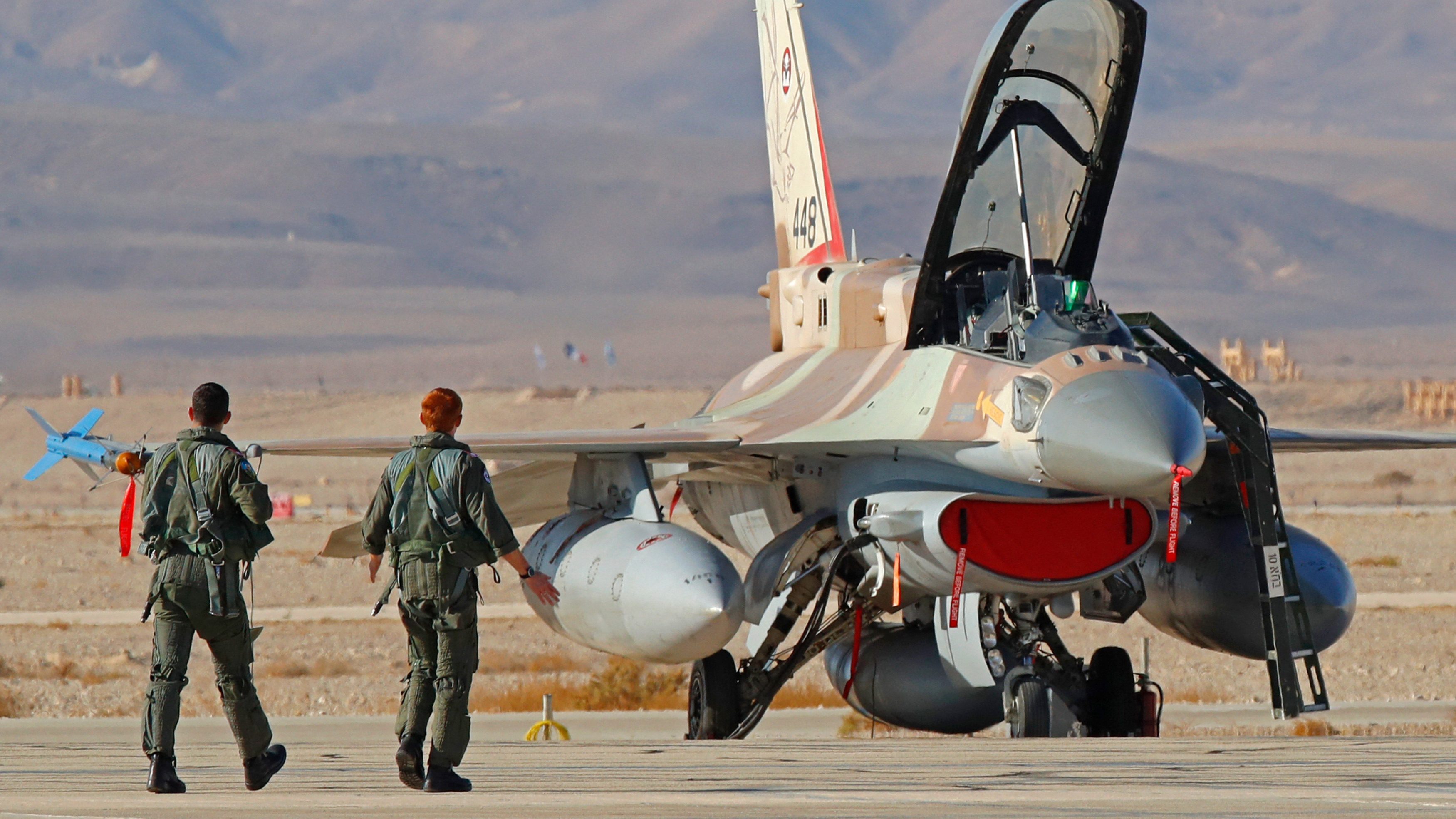 Israeli air force pilots walk to their F-16 fighters during an air defence exercise at the Ovda air force base, north of the Israeli city of Eilat, 24 October  2021 (AFP)