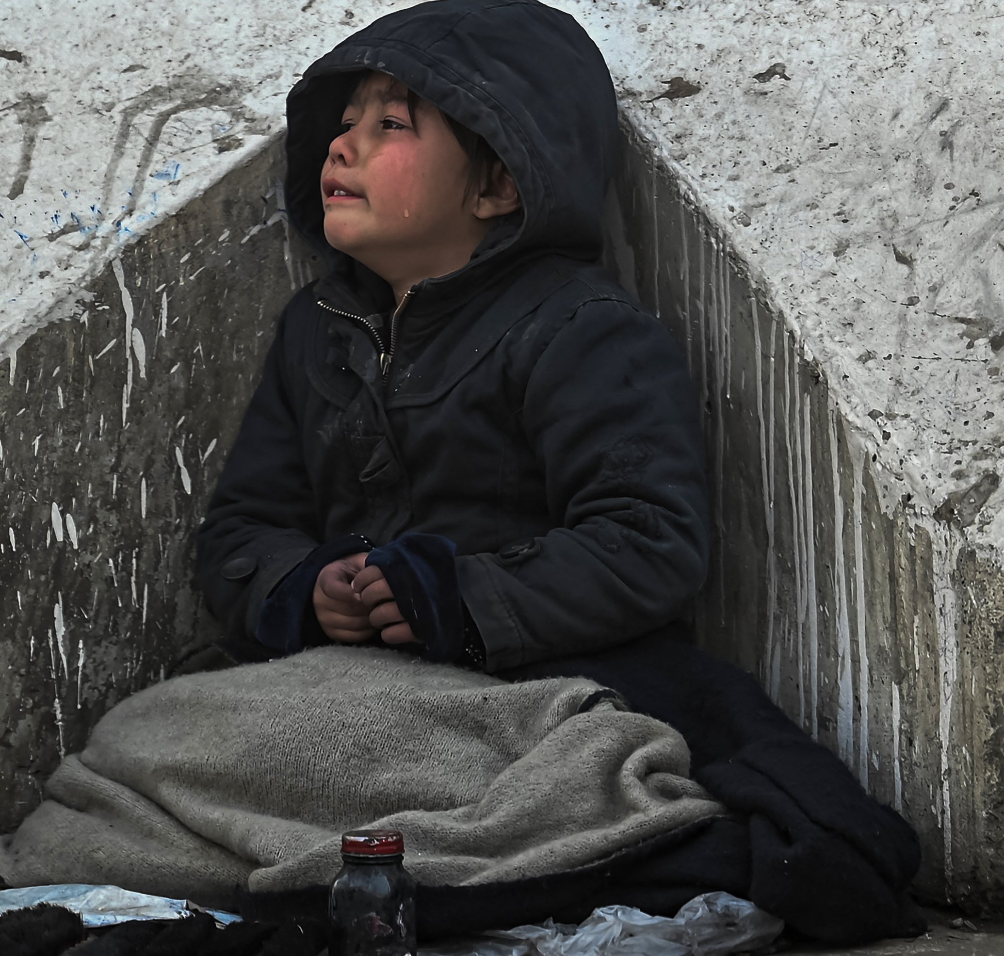 Un enfant pleure sur un trottoir à Kaboul, le 27 décembre 2021 (AFP)