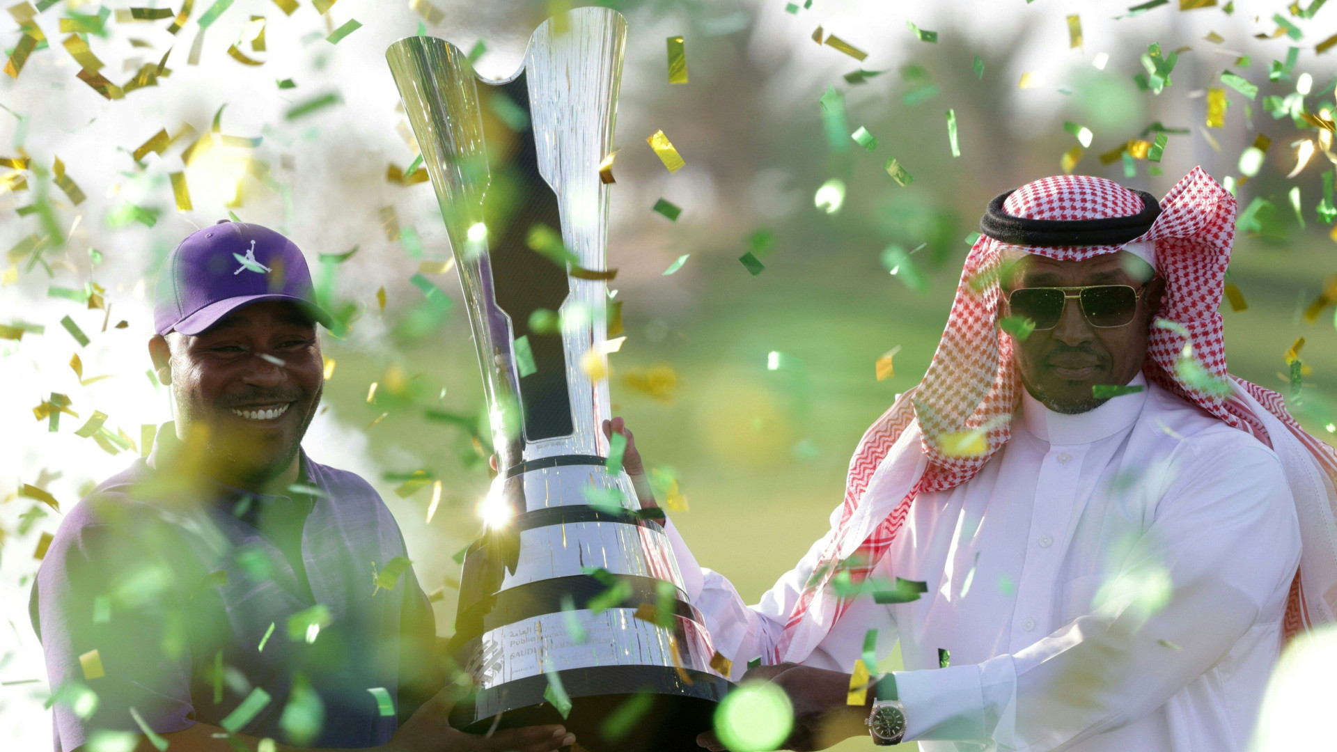 American Harold Varner III is presented the trophy by the deputy chairman of Saudi Golf Federation Majed al-Sorour after winning the PIF Saudi International in Jeddah, on 6 February, 2022. (AFP)