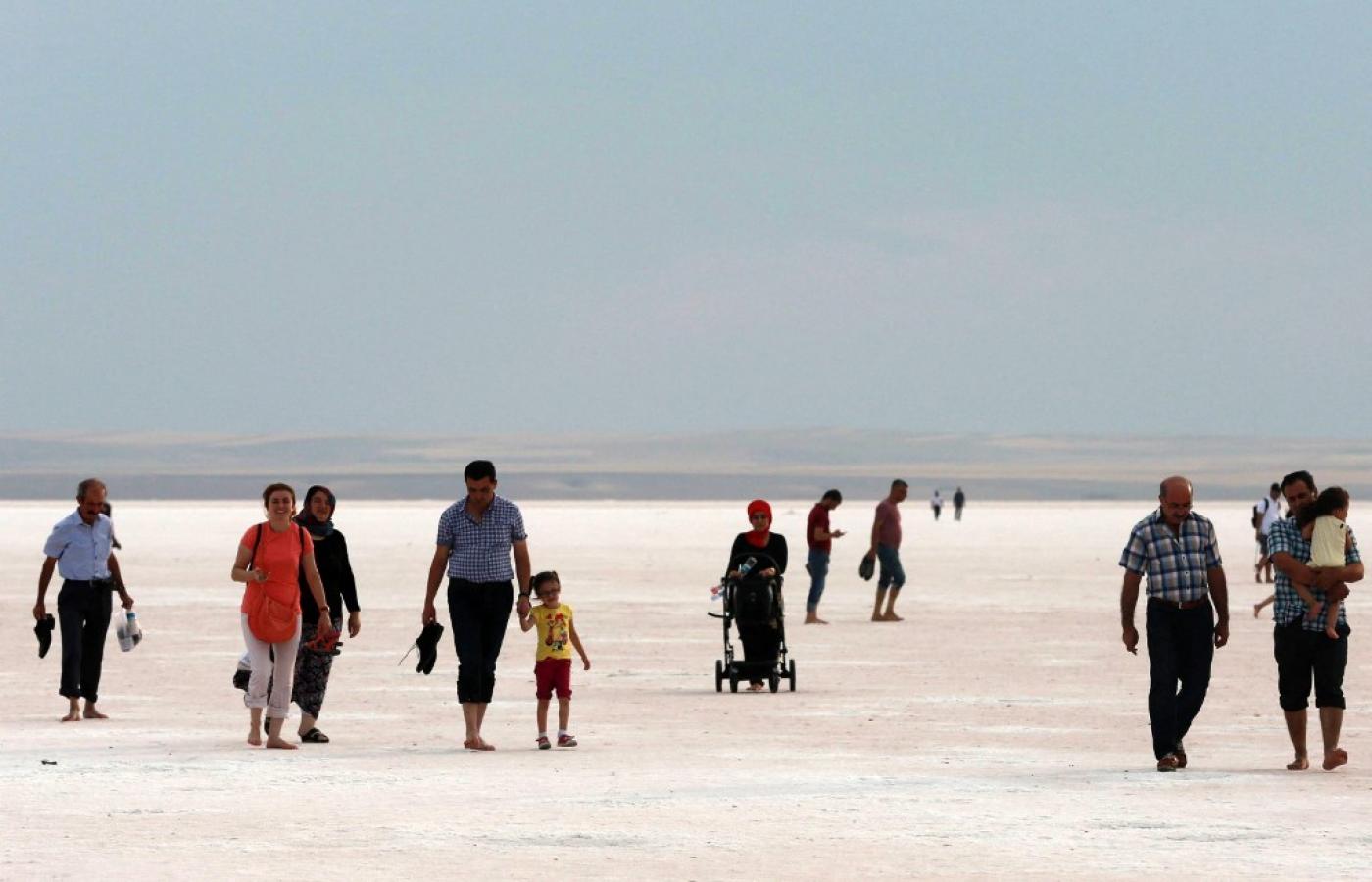 Des touristes traversent le lit asséché du lac Tuz, en Turquie. La moitié de la production turque de sel de table provient des usines situées autour du lac (AFP)