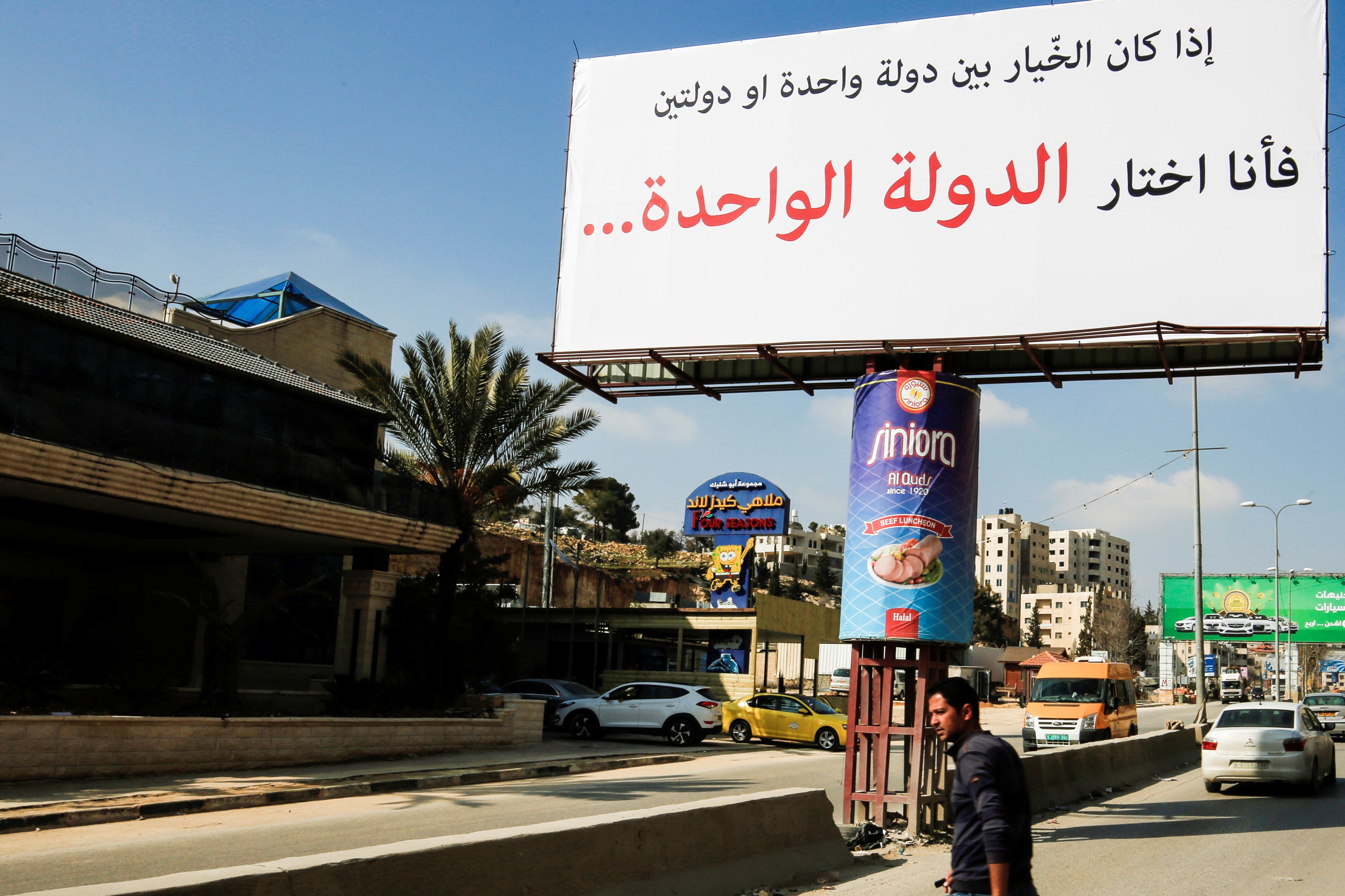 A picture taken on February 23, 2017 shows a billboard, of unknown origin, on a main road leading to the West Bank city of Ramallah, reading in Arabic: "If the choice is between one state or two states, then I am choosing the one state."