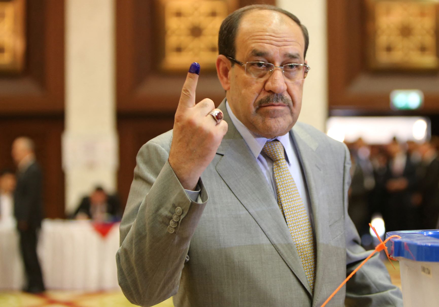 Iraqi Prime Minister Nuri al-Maliki shows his ink-stained finger after casting his vote in Iraqi elections in 2014 (AFP)