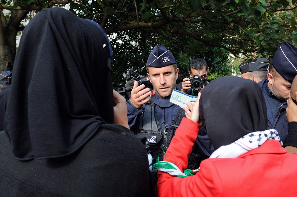 A French police officer stops Muslim women for an identity check on 22 September 2012 near the police station of Lille in the North of France (AFP)