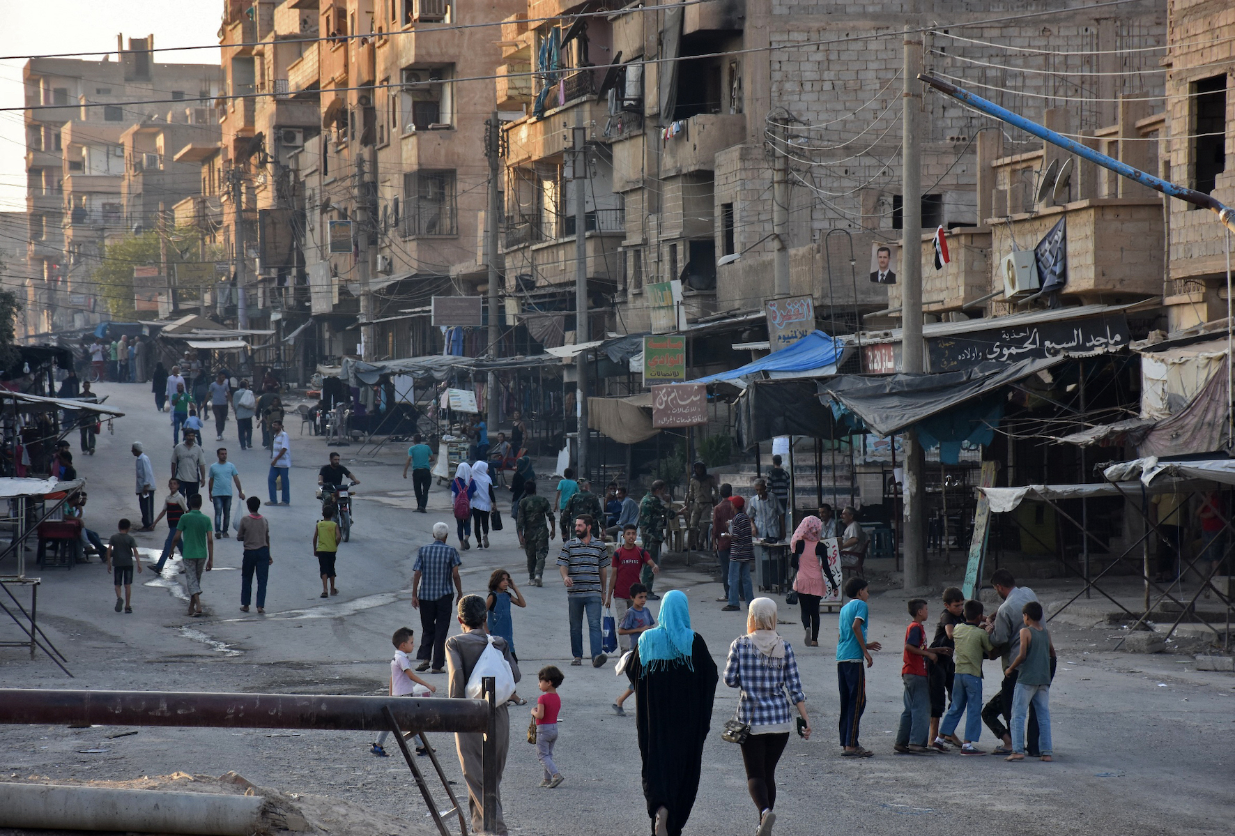 A general view shows Syrians walking down a street in the eastern city of Deir Ezzor (AFP/ George Ourfalian)