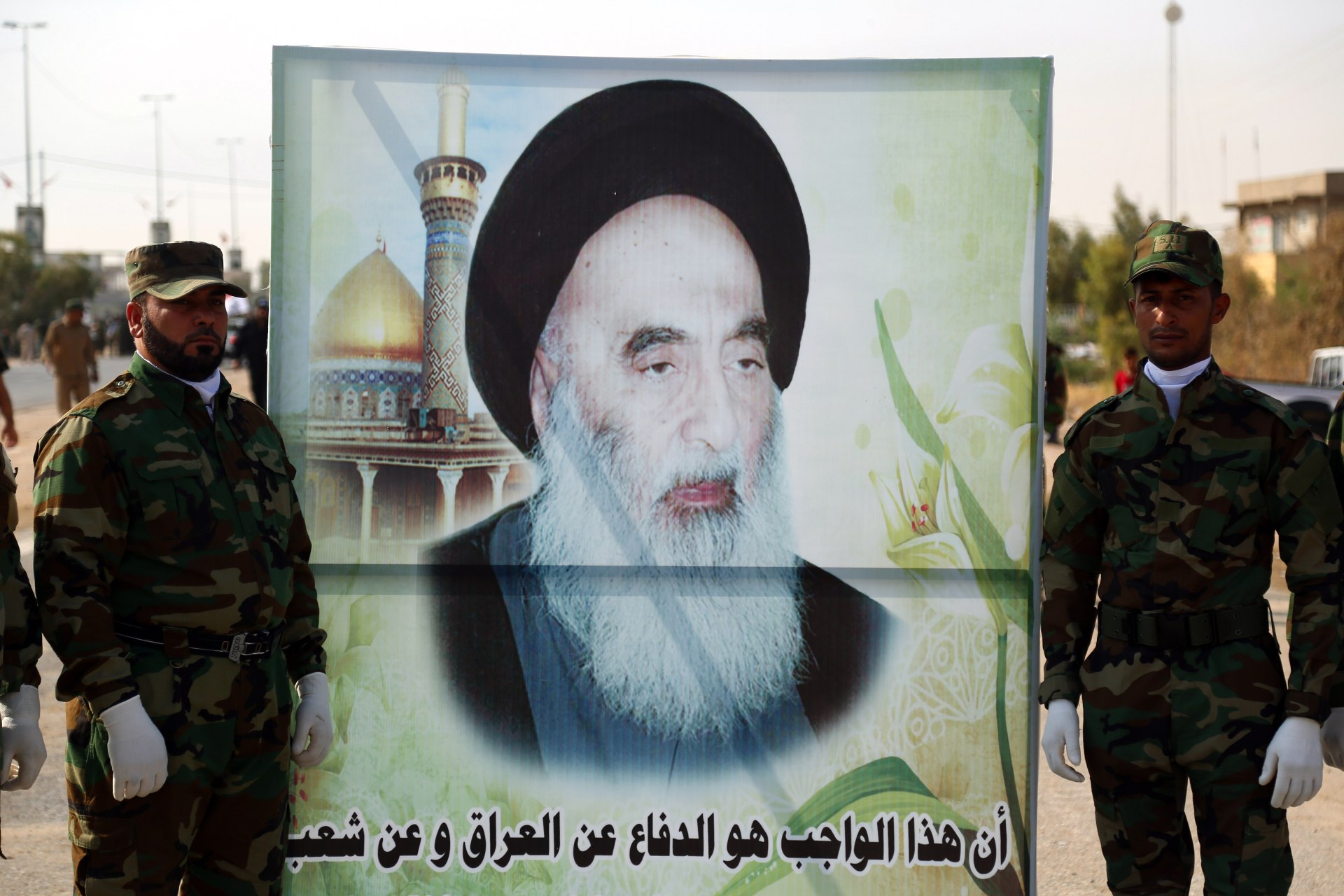 Members of the Popular Mobilisation carrying a large banner depicting the image of Shiite cleric Grand Ayatollah Ali al-Sistani in Najaf (AFP)