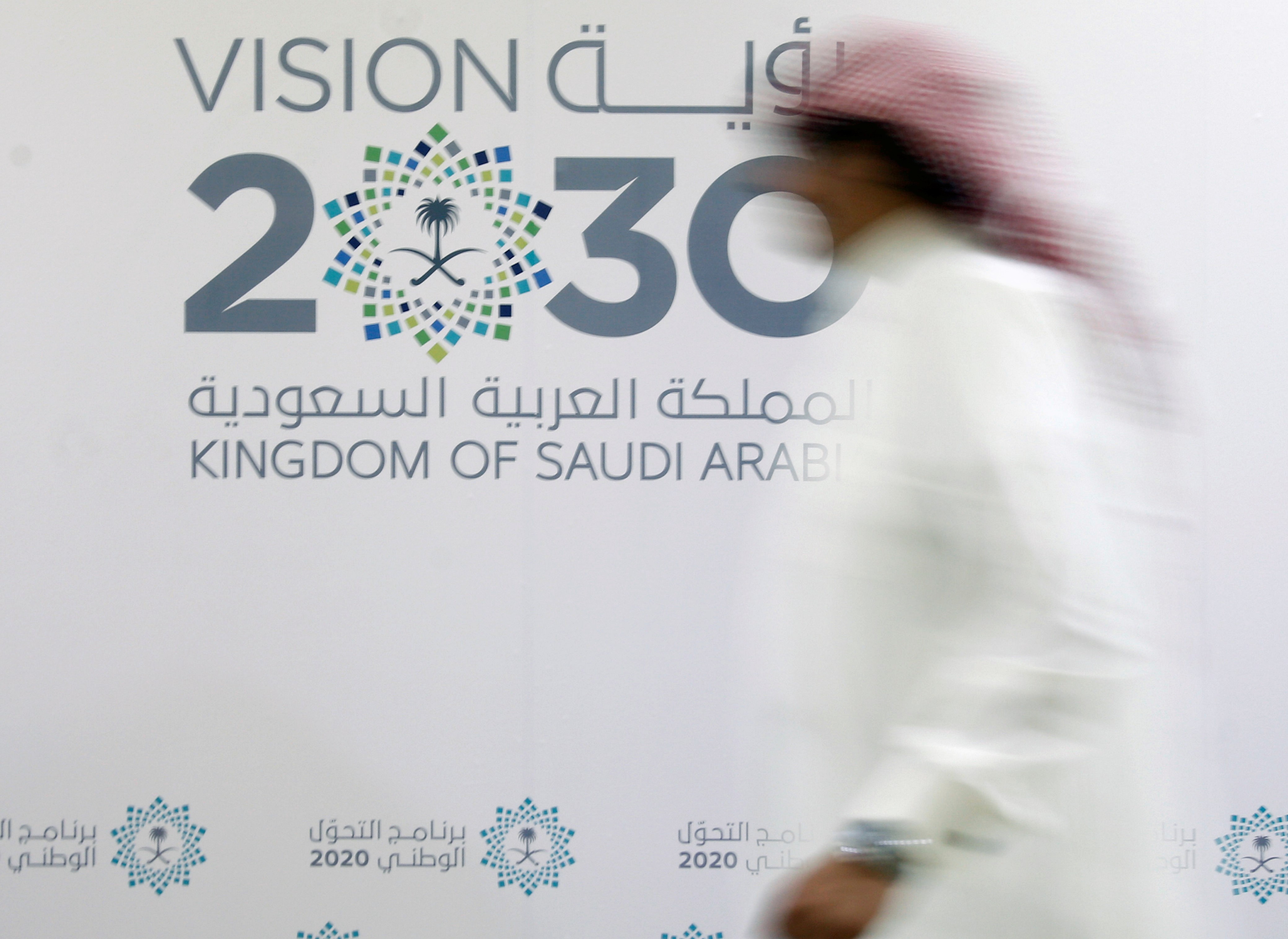  A man walks past the logo of Vision 2030 after a news conference, in Jeddah, Saudi Arabia June 7, 2016.
