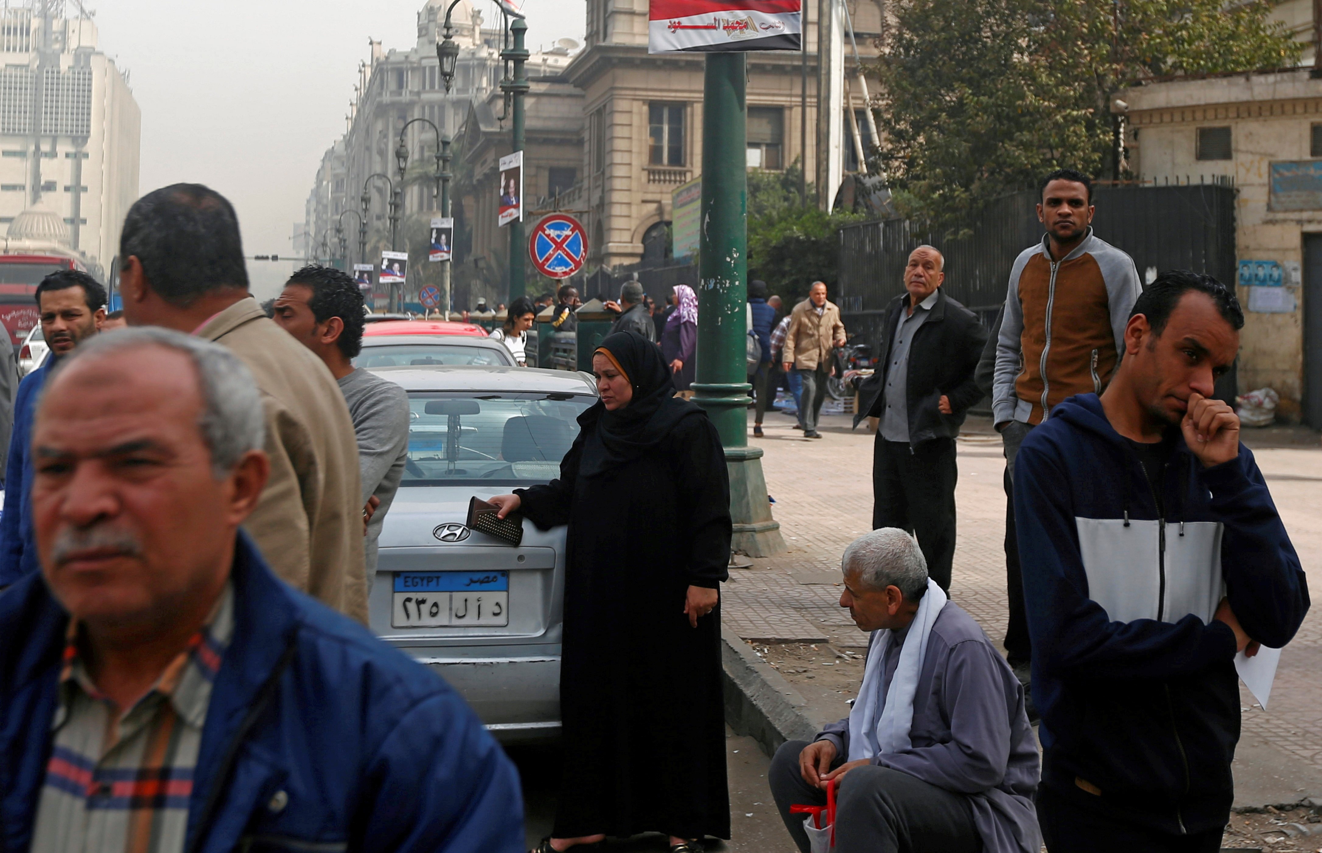 Des Égyptiens attendent le bus près d’une affiche représentant le président égyptien Abdel Fattah al-Sissi au Caire, le 8 février 2018 (Reuters)