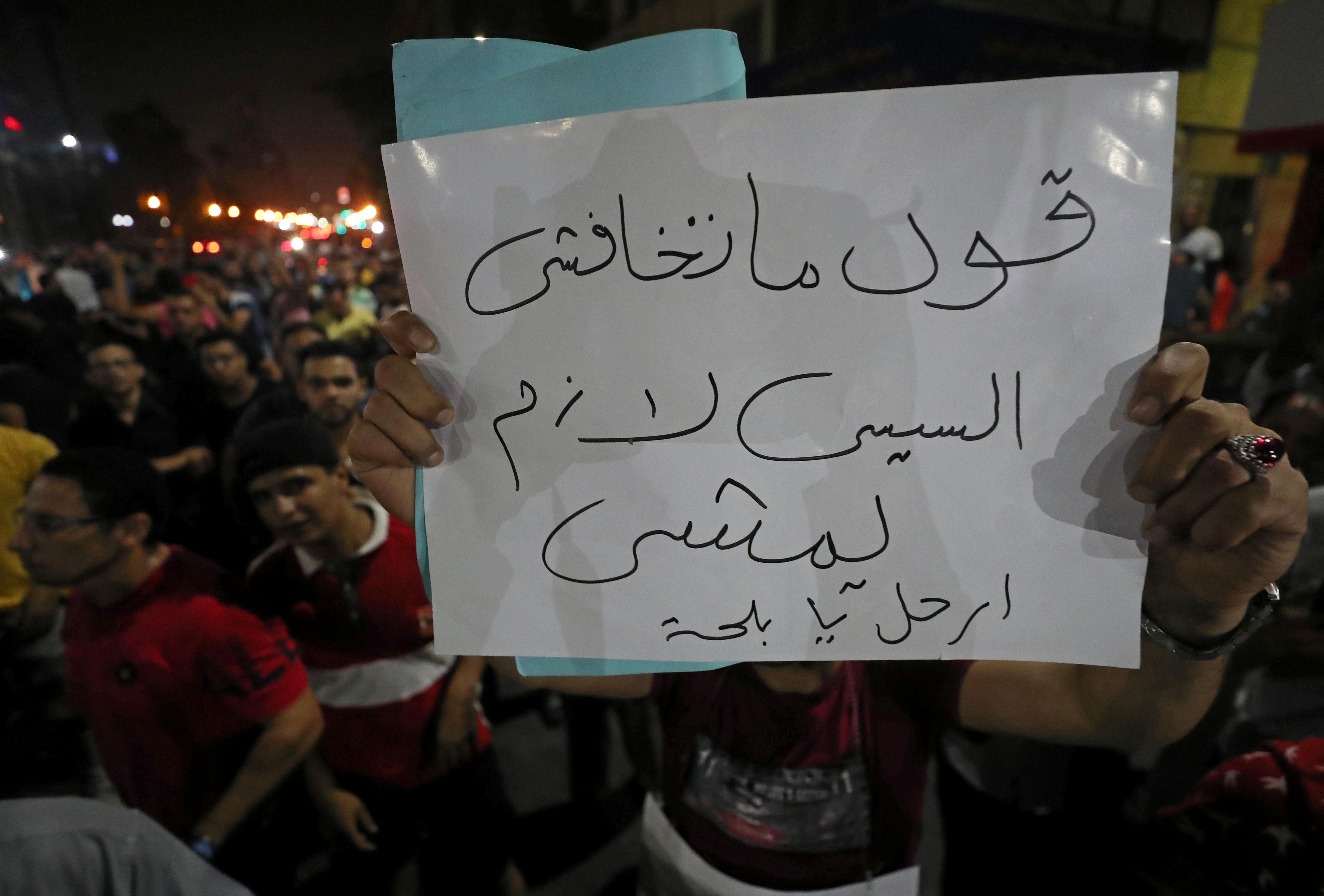 A protester carries a sign that reads "Don't be afraid ..say .. Sisi must leave" while protesters gather in central Cairo shouting anti-government slogans in Cairo, Egypt on 21 September (Reuters)