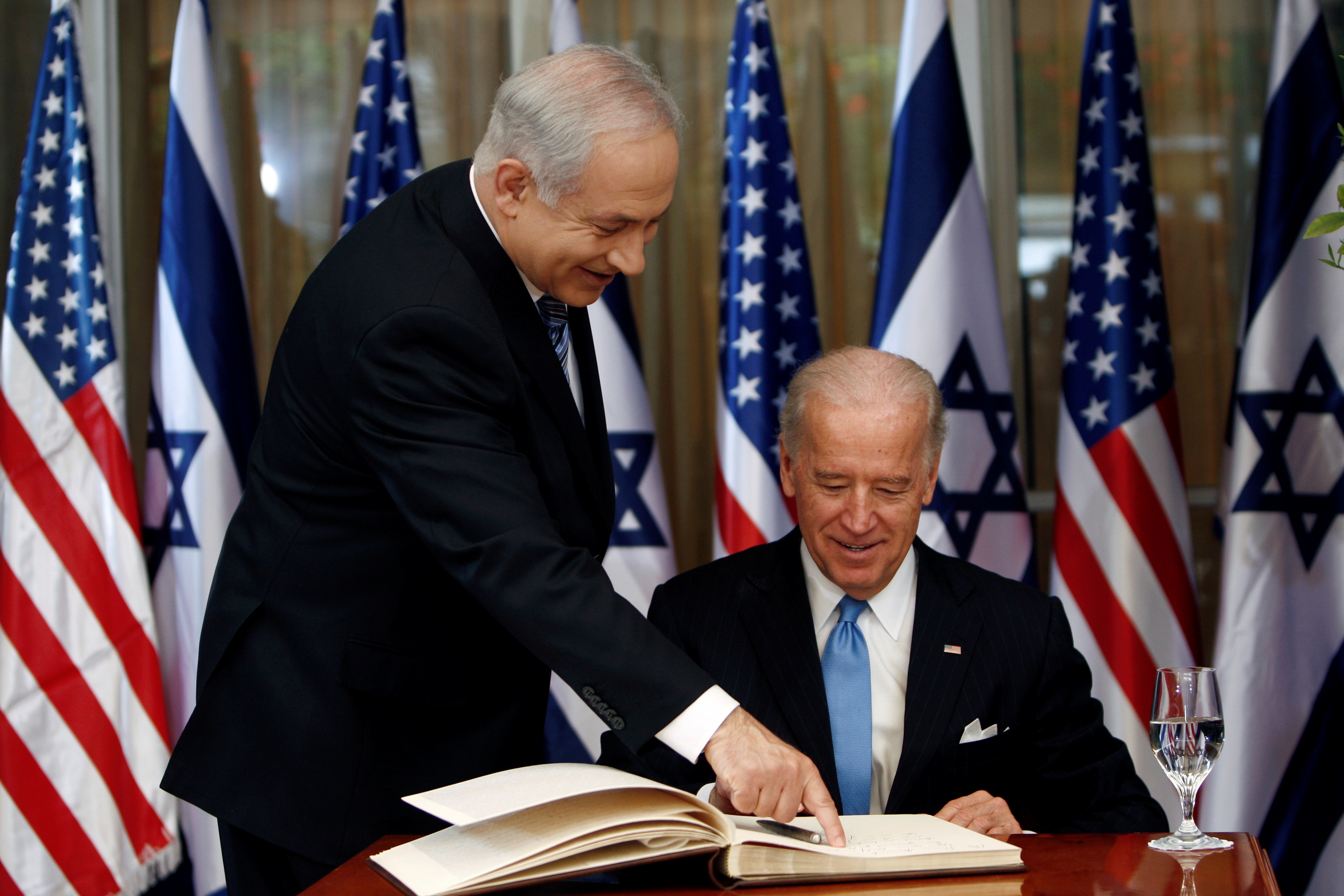 Joe Biden (R) prepares to sign the guest book at his meeting with Israel's Prime Minister Benjamin Netanyahu at the Israeli PM's residence in Jerusalem, 9 March 2010 (Reuters)