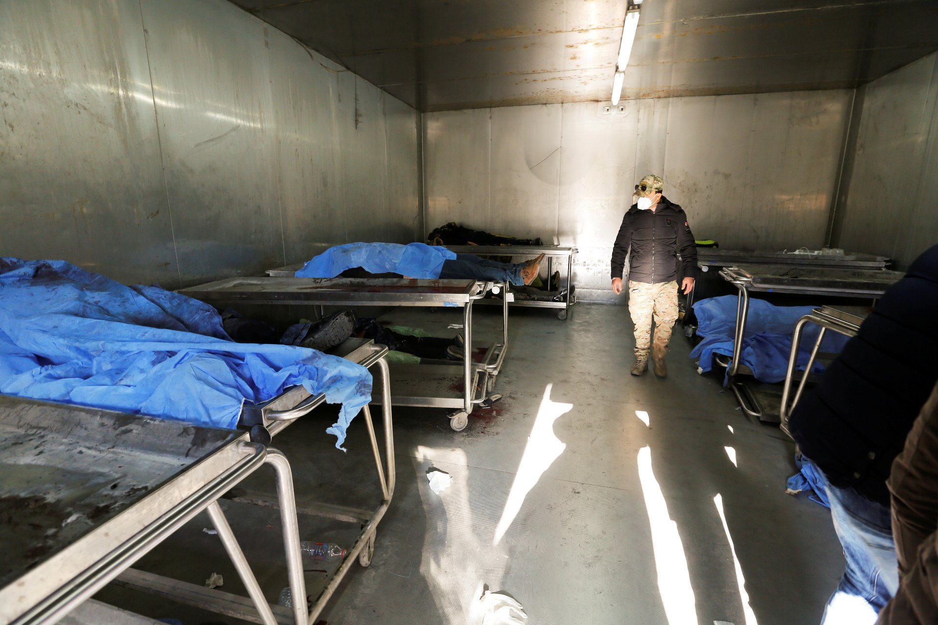 A man looks at the covered bodies of people who were killed during a twin suicide bombing attack in a central Baghdad market, at the al-Kindi hospital morgue in Baghdad (Reuters)