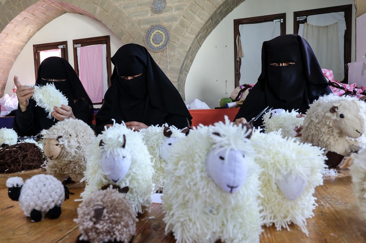 Des Palestiniennes fabriquent des jouets en mouton avant l’Aïd al-Adha, dans le village bédouin de Umm al-Nasr, dans le nord de la bande de Gaza, le 14 juillet 2021 (AFP/Mohammed Abed)