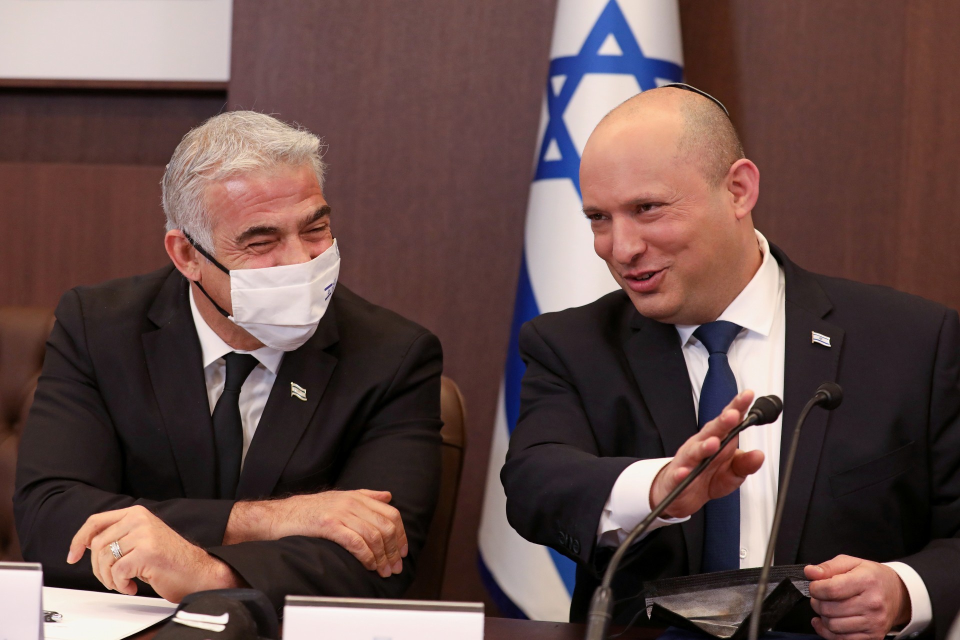 Israeli Prime Minister Naftali Bennett speaks with Foreign Minister Yair Lapid at a weekly cabinet meeting in Jerusalem, 5 December (Reuters)