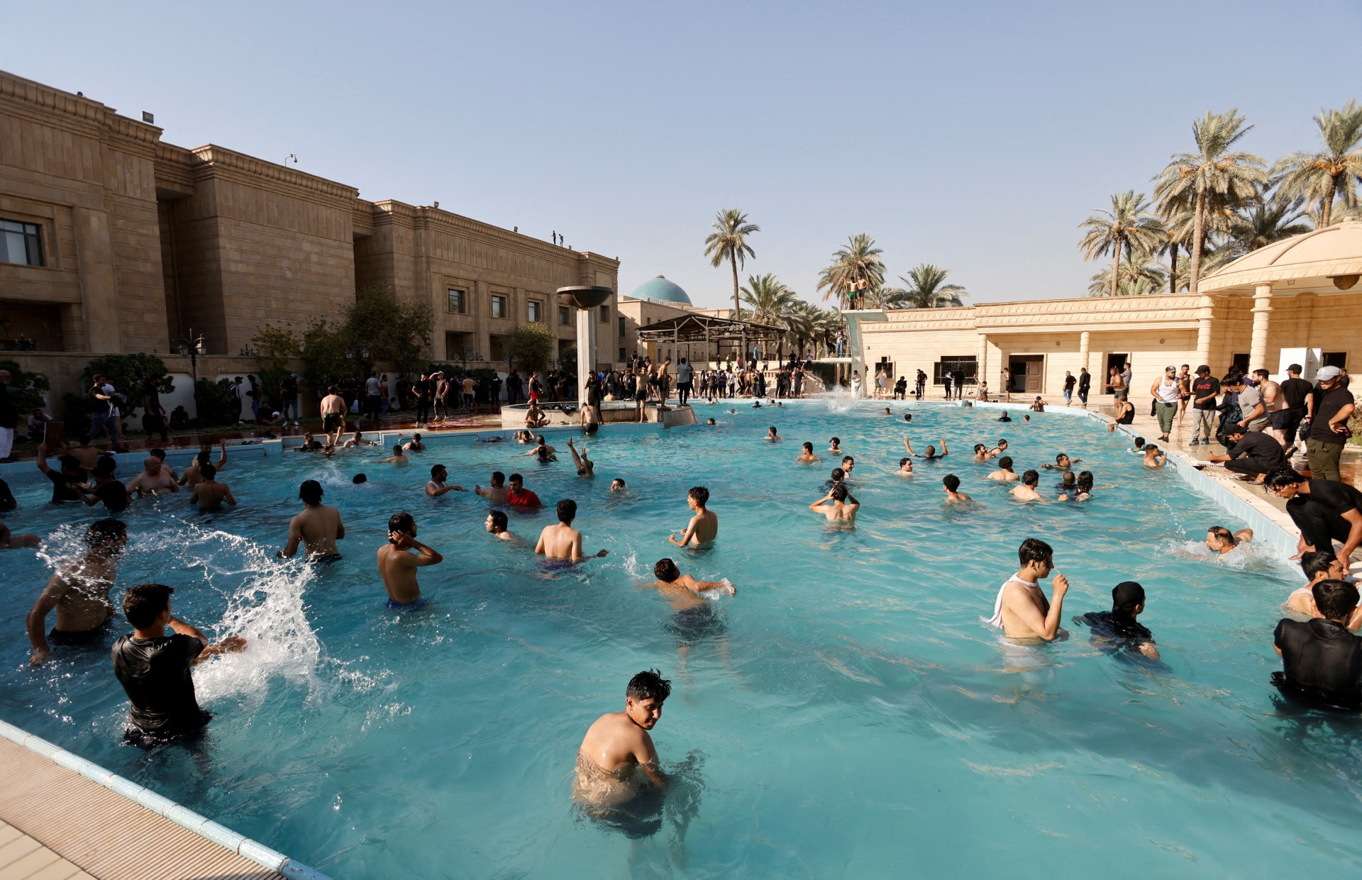 Supporters of Muqtada al-Sadr swim as they protest inside the Republican Palace in the Green Zone, in Baghdad, 29 August (Reuters)