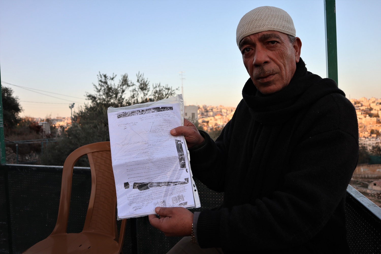 Khaled Abou Aicha montre son contrat de location jordanien, preuve qu’il possède toujours les magasins dont il a été forcé de partir en 2002, sous ordre des autorités israéliennes (MEE/Marie Niggli)