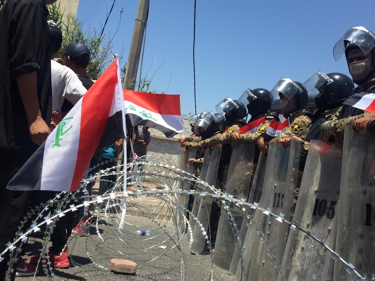 Iraqi security force prevent protesters coming close to a governmental building in Basra (Azhar Al-Rubaie)