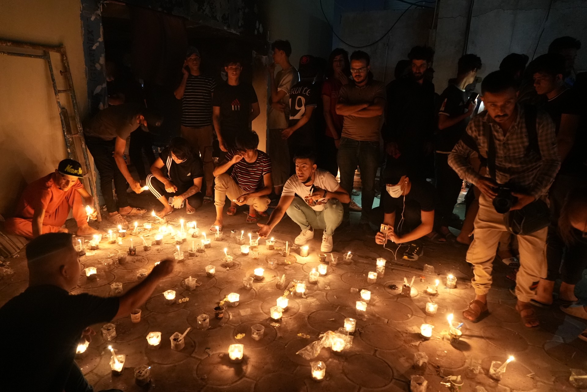 People light candles at the remains of the torched ward in memory of the dead (MEE/Azhar Al-Rubaie)