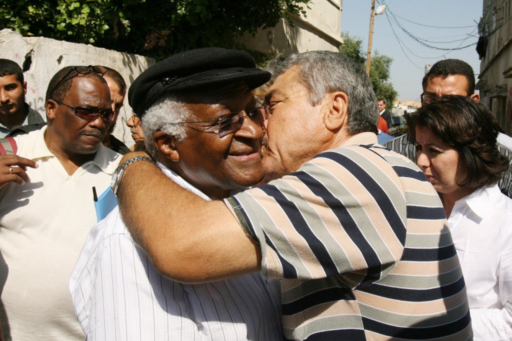 A member of the Palestinian al-Asamneh family embraces Nobel peace laureate Desmond Tutu during his visit to the family in Beit Hanun in the northern Gaza Strip, 28 May 2008 