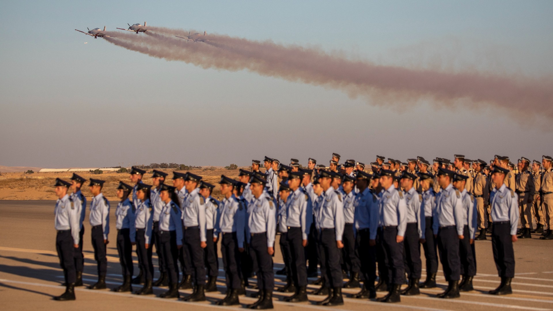 Israeli air force jets team fly over cadets during a graduation ceremony for new pilots in Hatzerim air force base near Beersheba, Israel in 2021 (AP)
