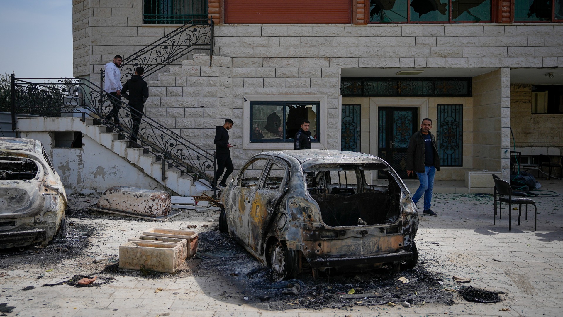 Palestinians inspect a damaged house and scorched cars in the town of Huwwara, near the West Bank city of Nablus, 27 February (AP)