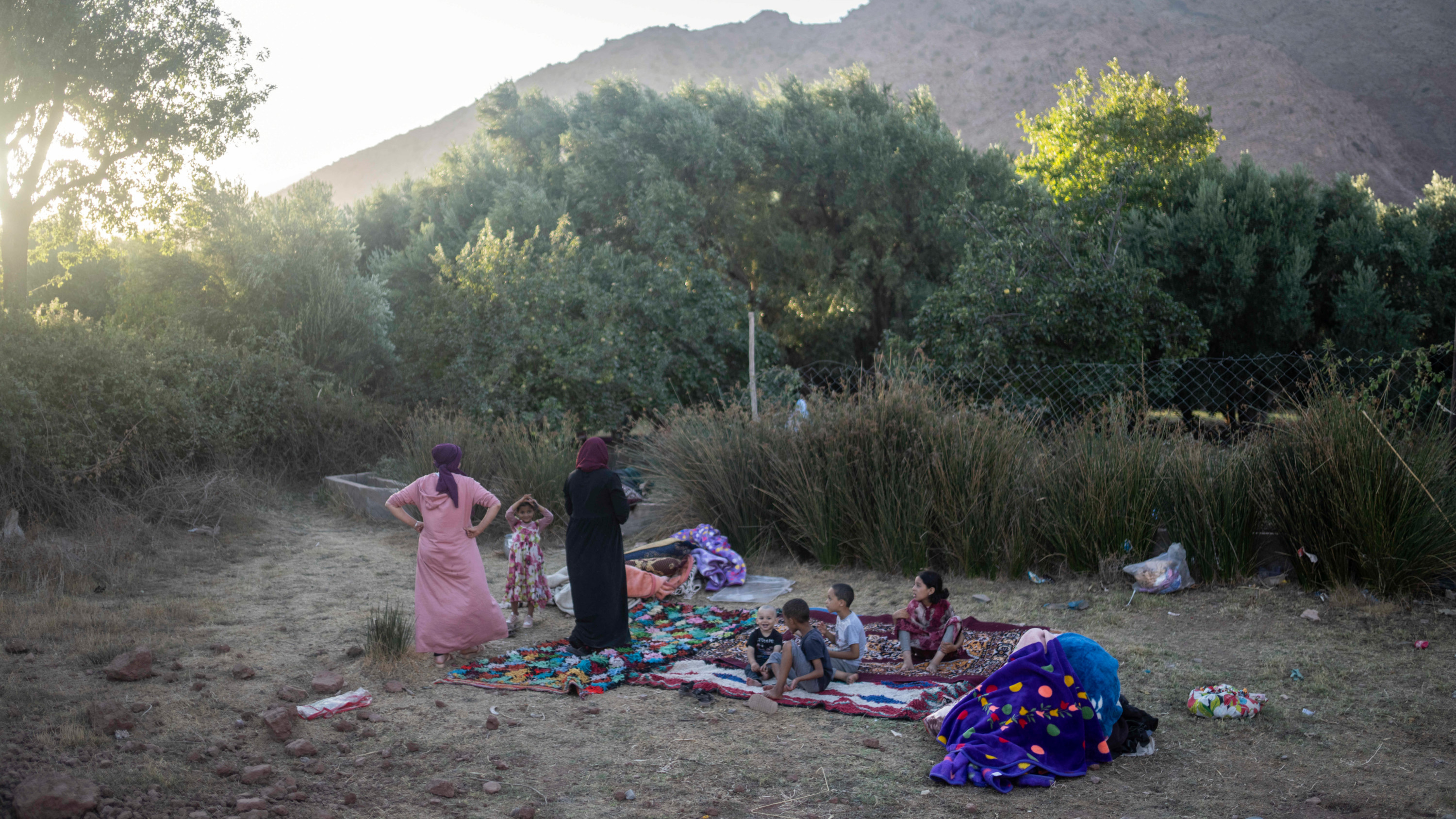 Une famille dont la maison a été endommagée par le séisme s’installe pour la nuit dans une exploitation agricole, le 9 septembre 2023 dans le village d’Ijoukak, près de Marrakech (AP)