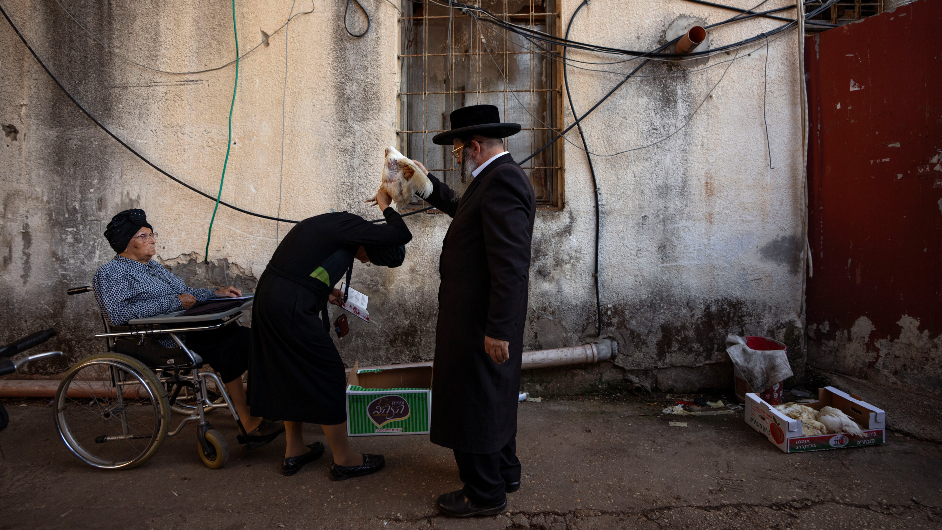 An ultra-Orthodox Jewish man swings a chicken over his wife as part of the Kaparot ritual in Bnei Brak, Israel 21 September 2023 (AP)