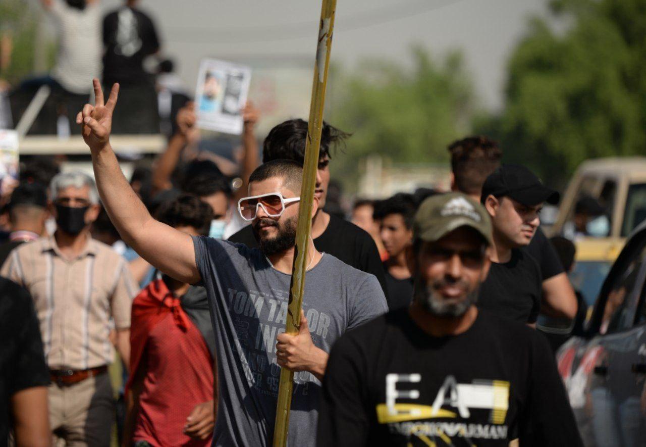 An Iraqi protester making the victory sign nearby Al-Tahrir Square.