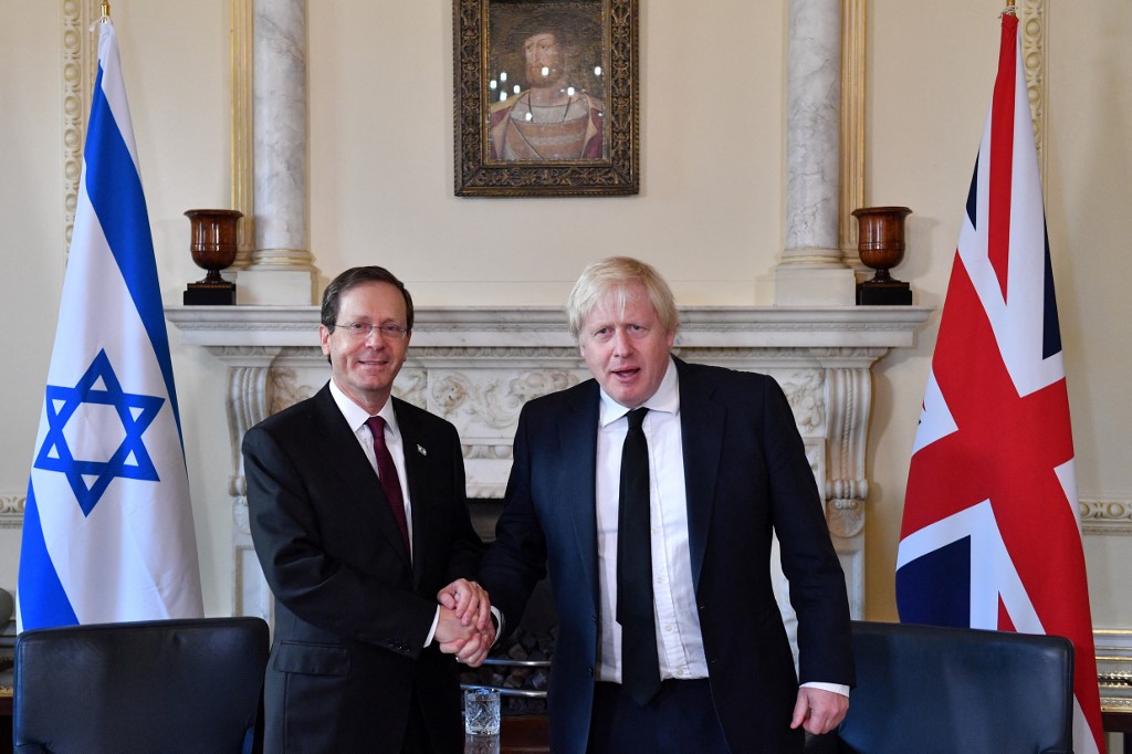 Britain's then-Prime Minister Boris Johnson (R) shakes hands with Israeli President Isaac Herzog at No 10 Downing Street, London on 23 November 2021 (AFP)