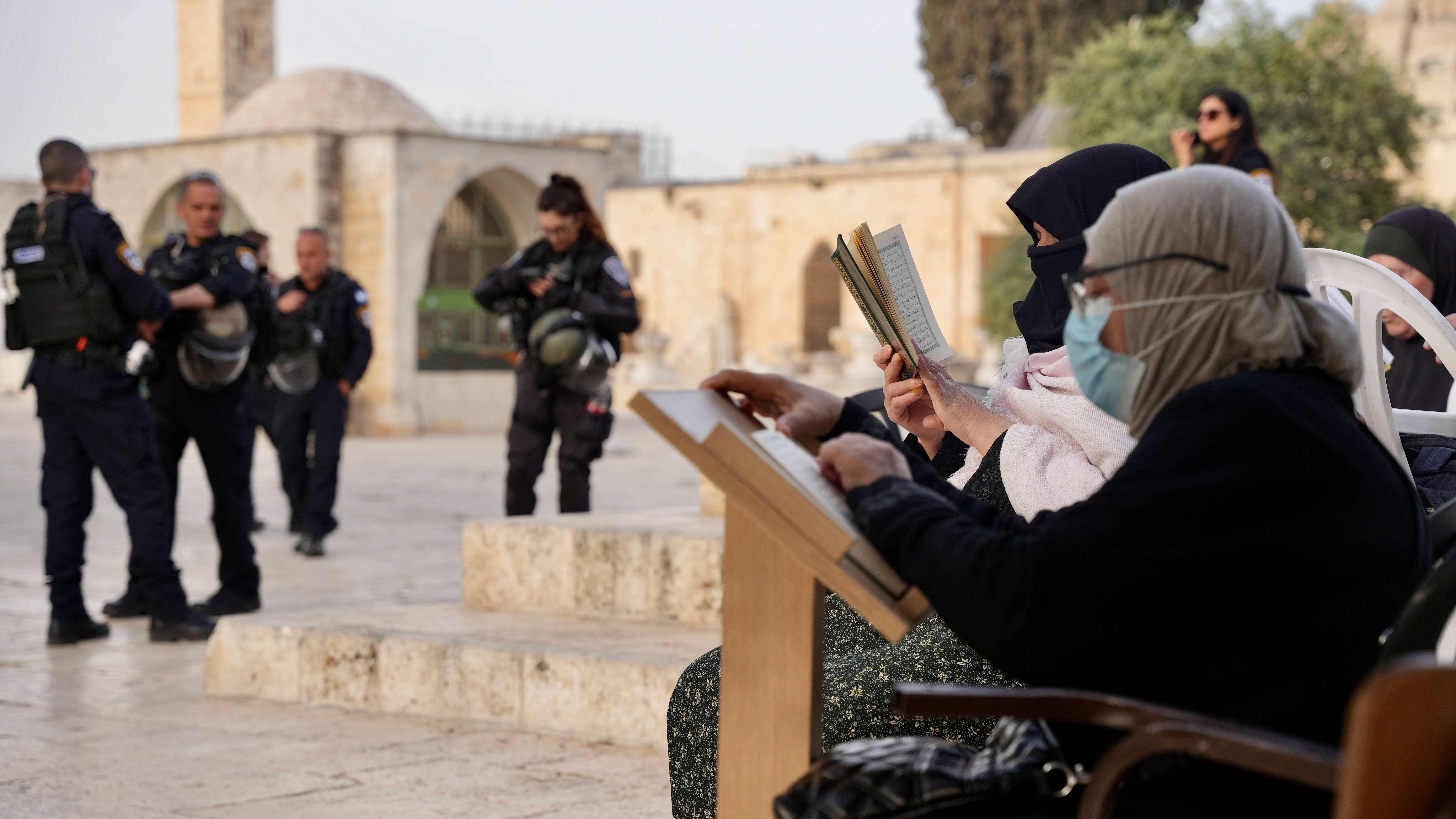 Palestinian women recite the Quran in the courtyards of Al-Aqsa Mosque while Israeli police secure incursions by ultranationalists on 9 April 2023 (MEE/Latifeh Abdellatif)