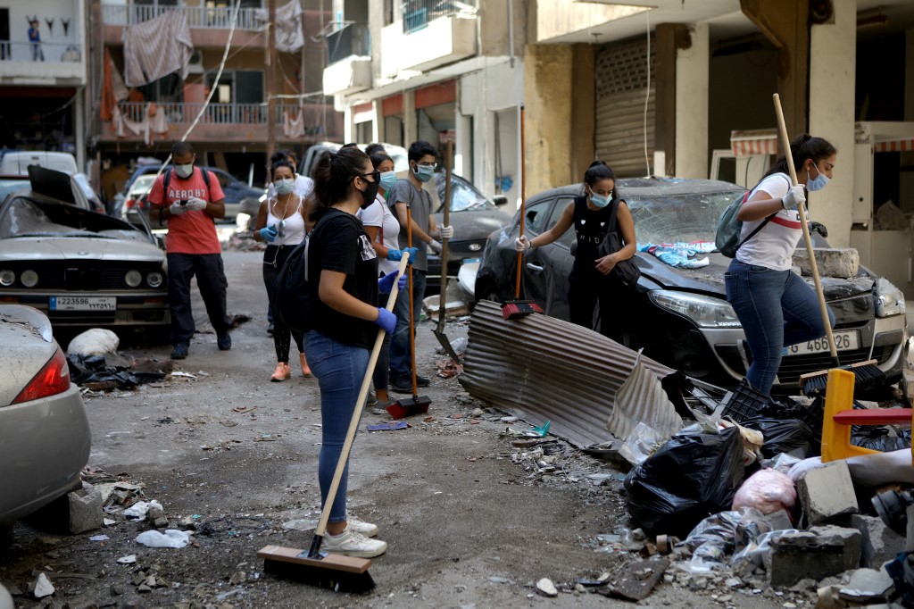 Des bénévoles et membres de la société civile nettoient les décombres dans une rue de Mar Mikhael à Beyrouth le 6 août 2020 après l’explosion du port (AFPPatrick Baz)