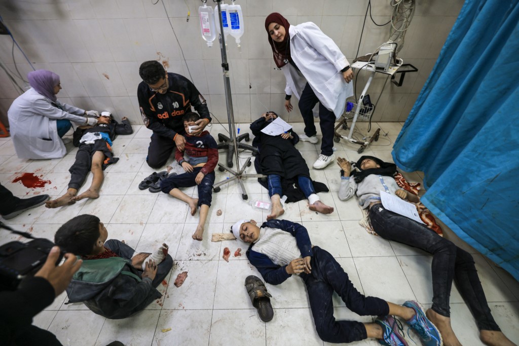 Medics at Nasser Hospital in Khan Yunus help the Al-Qedra family who were injured by Israeli bombardment (Mahmud Hams/AFP)