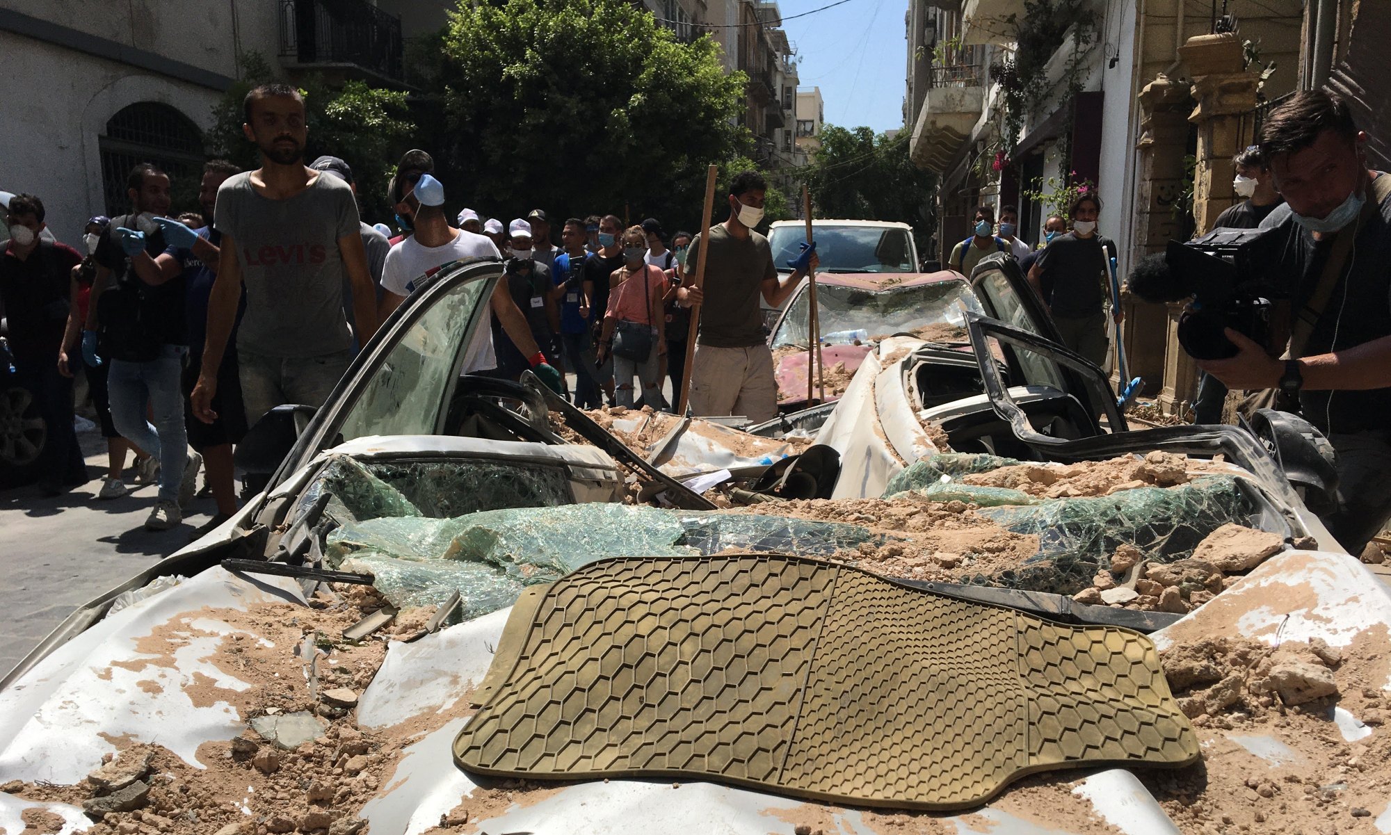 Volunteers scurry across the Beirut neighbourhood of Mar Mikhael clearing rubble and glass from demolished buildings on 6 August 2020 (MEE/Kareem Chehayeb)