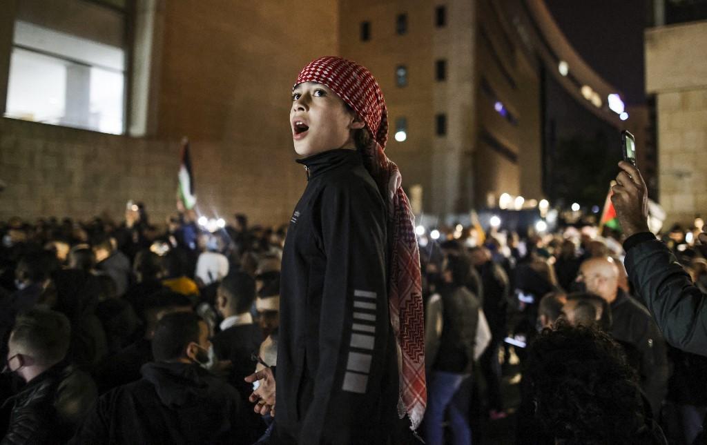 A young demonstrator chants slogans outside the Haifa District Court in Israel's northern Mediterranean coastal city on February 27, 2021, during a protest by Arab Israelis against violence against their community and in solidarity with protesters that were arrested the previous day in Umm al-Fahem.