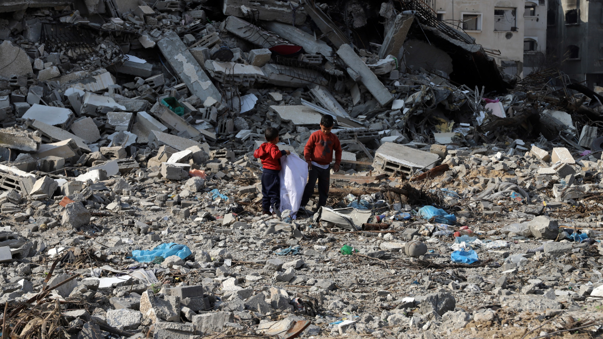 Children look through the rubble of their flattened homes in Gaza City 12 January 2023 (MEE/Mohammed al-Hajjar)