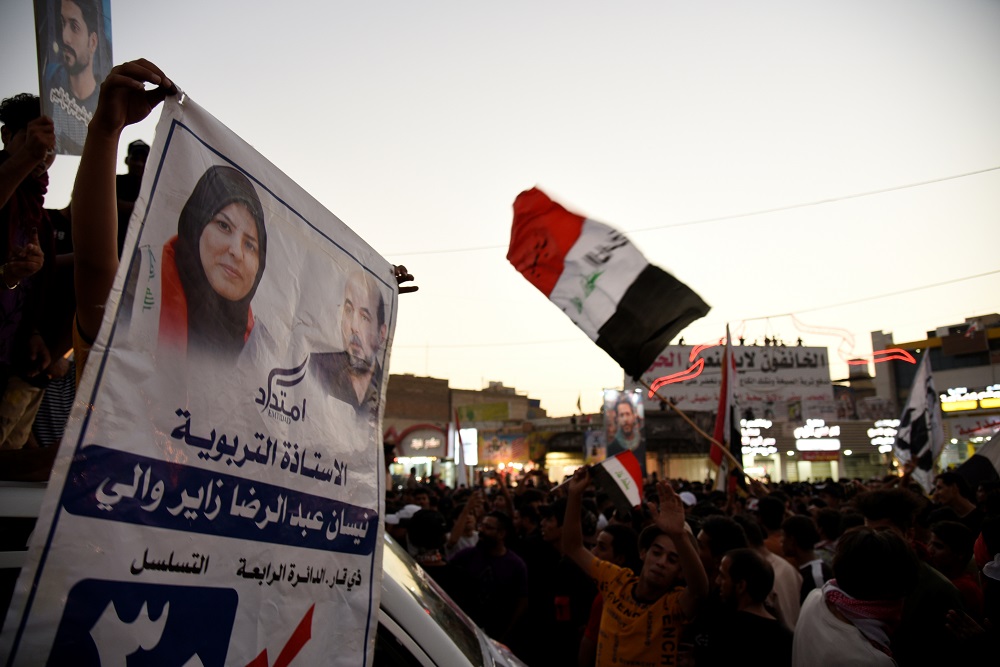 An Ititdad supporter holds up a poster showing Nissan Abdel-Redha al-Zayer
