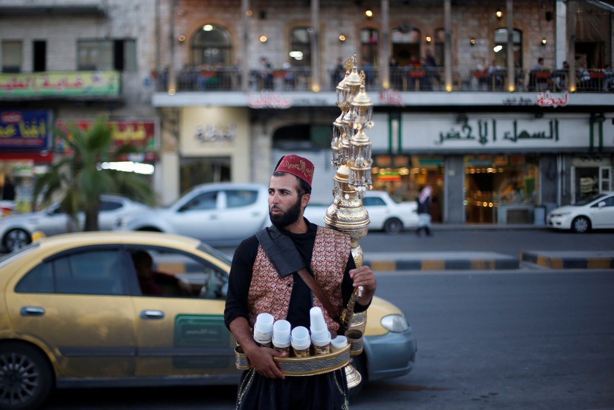A traditional juice vendor waits for customers at the Roman Amphitheatre area in downtown Amman (Reuters)