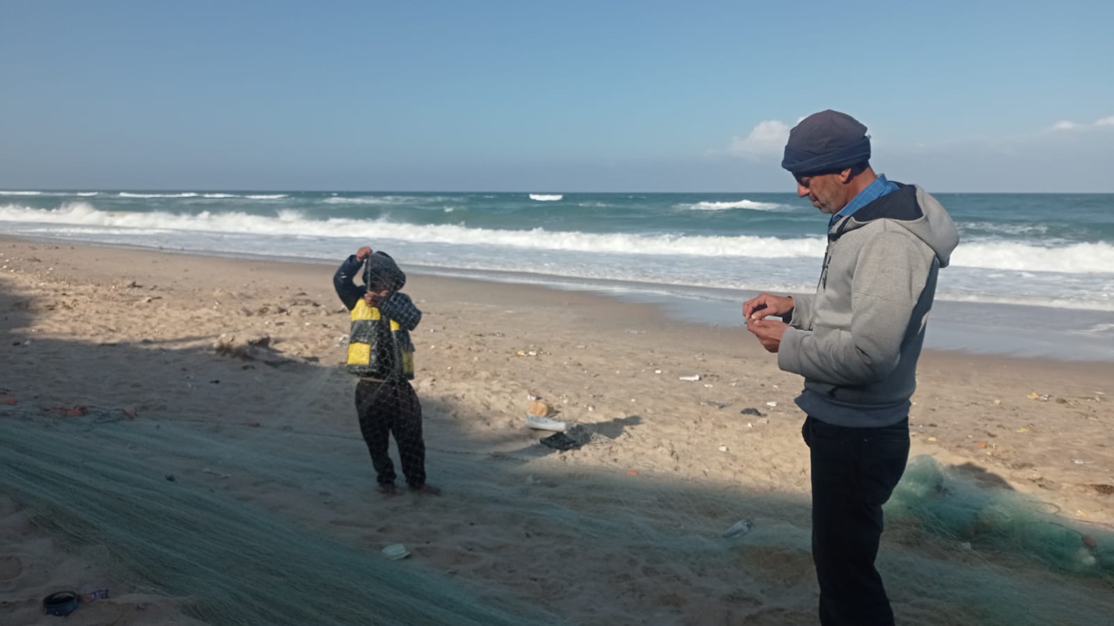 Mahmoud Hamada avec son fils sur la plage de Deir al-Balah peu avant qu’il ne soit tué (MEE/Abubaker Abed)