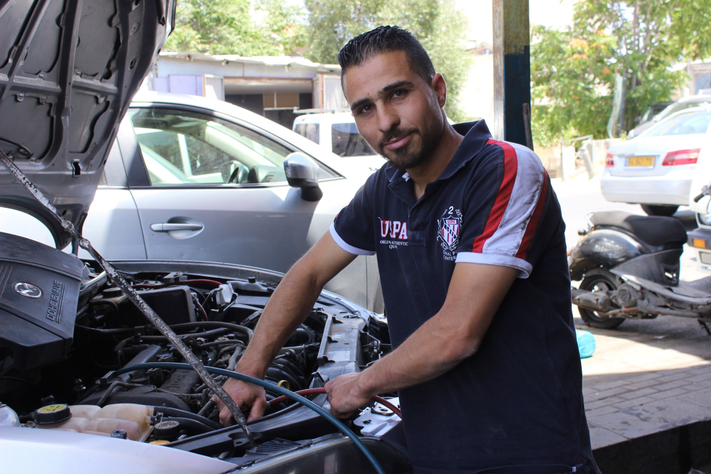 Mahmoud al-Kurd working at a garage shop in East Jerusalem