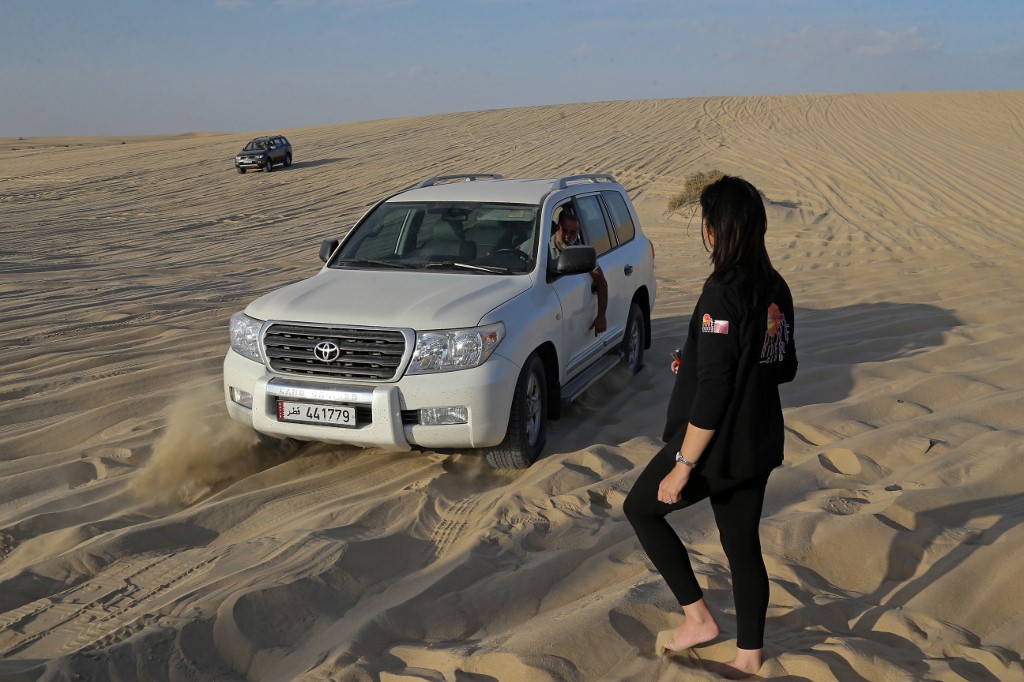 Marcelle Visser (à gauche), forme les participants aux techniques de conduite hors route dans le désert de Sealine au Qatar, le 8 janvier 2021 (AFP)