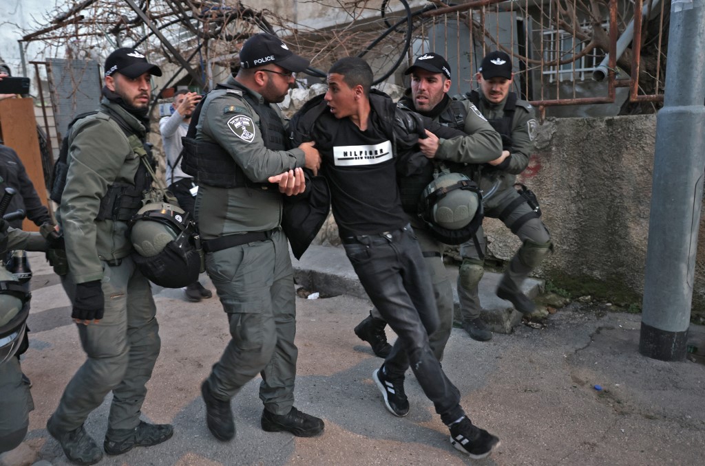 Members of the Israeli border guard detain a demonstrator during a protest in Sheikh Jarrah in Israeli-annexed East Jerusalem on 18 February 2022 (AFP)