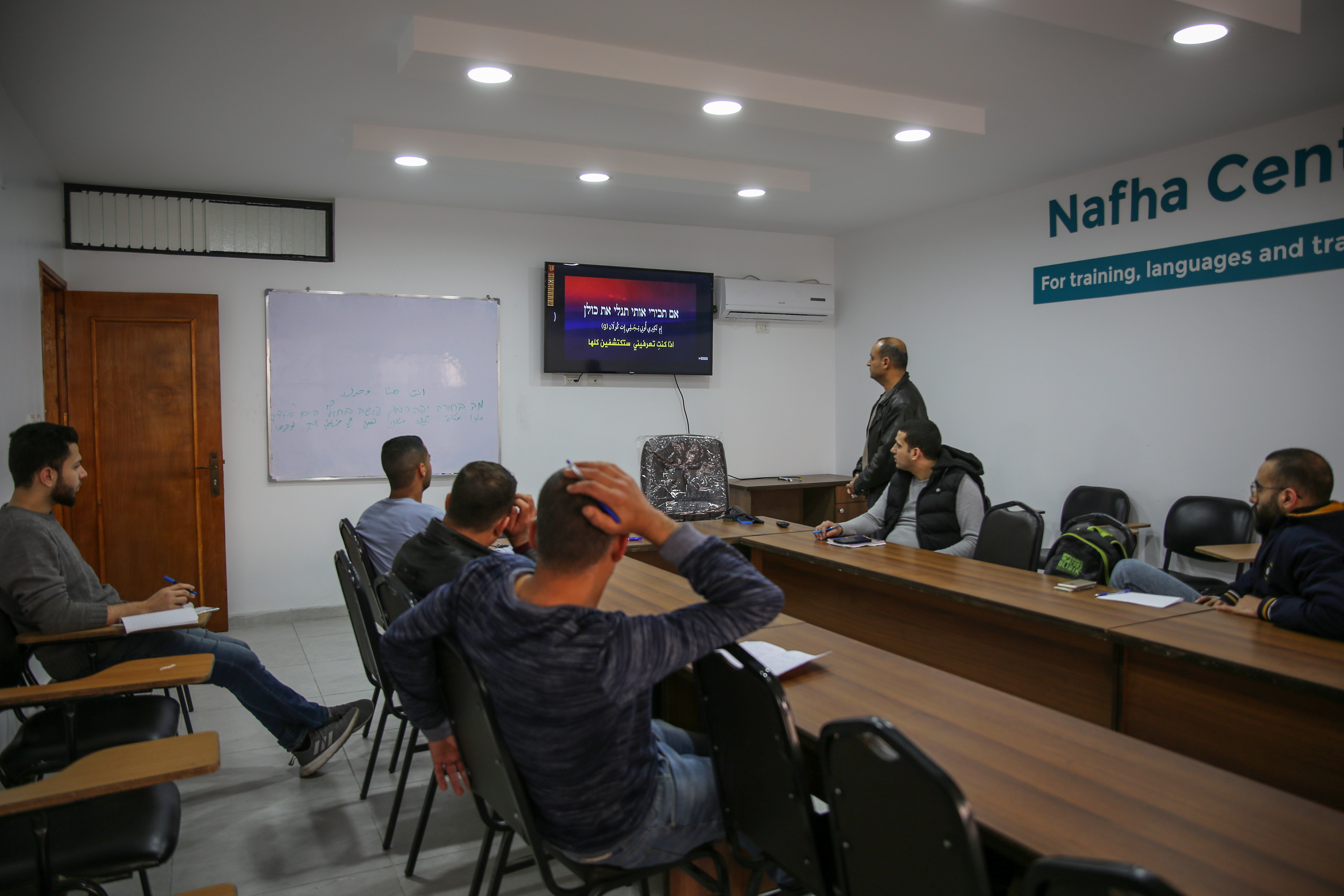 Homens que frequentam cursos de hebraico em Gaza para poderem se comunicar com seus empregadores em Israel (