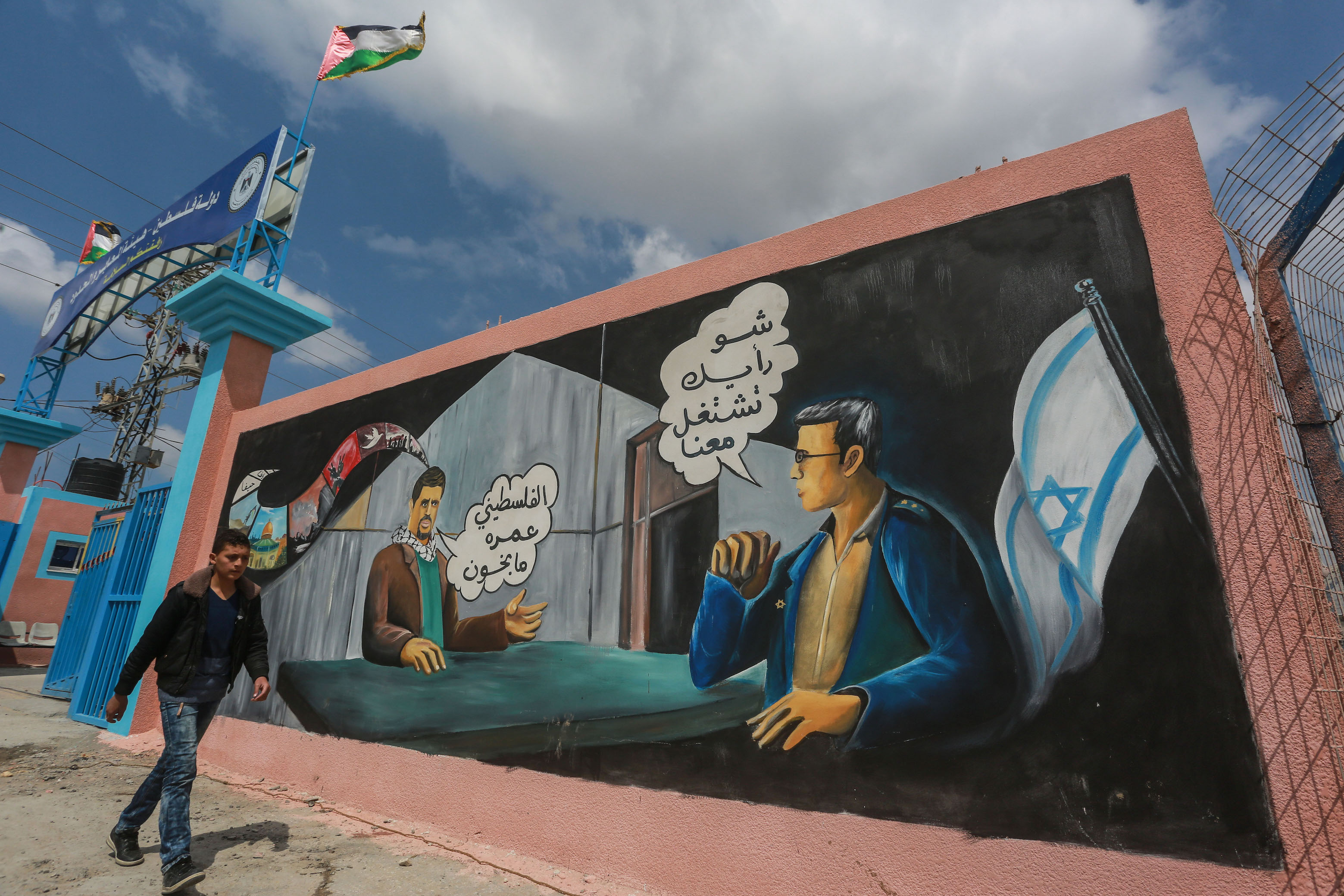 Mural perto da fronteira de Erez entre Gaza e Israel que diz 'O que você acha de trabalhar para Israel?', com a resposta 'O palestino não é um traidor' (Mohammed al-Hajjar/MEE)