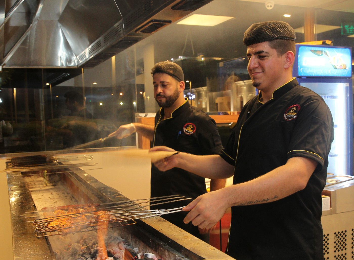 Workers grill meat at a restaurant in Doha, Qatar (MEE/Abu Muhammad)