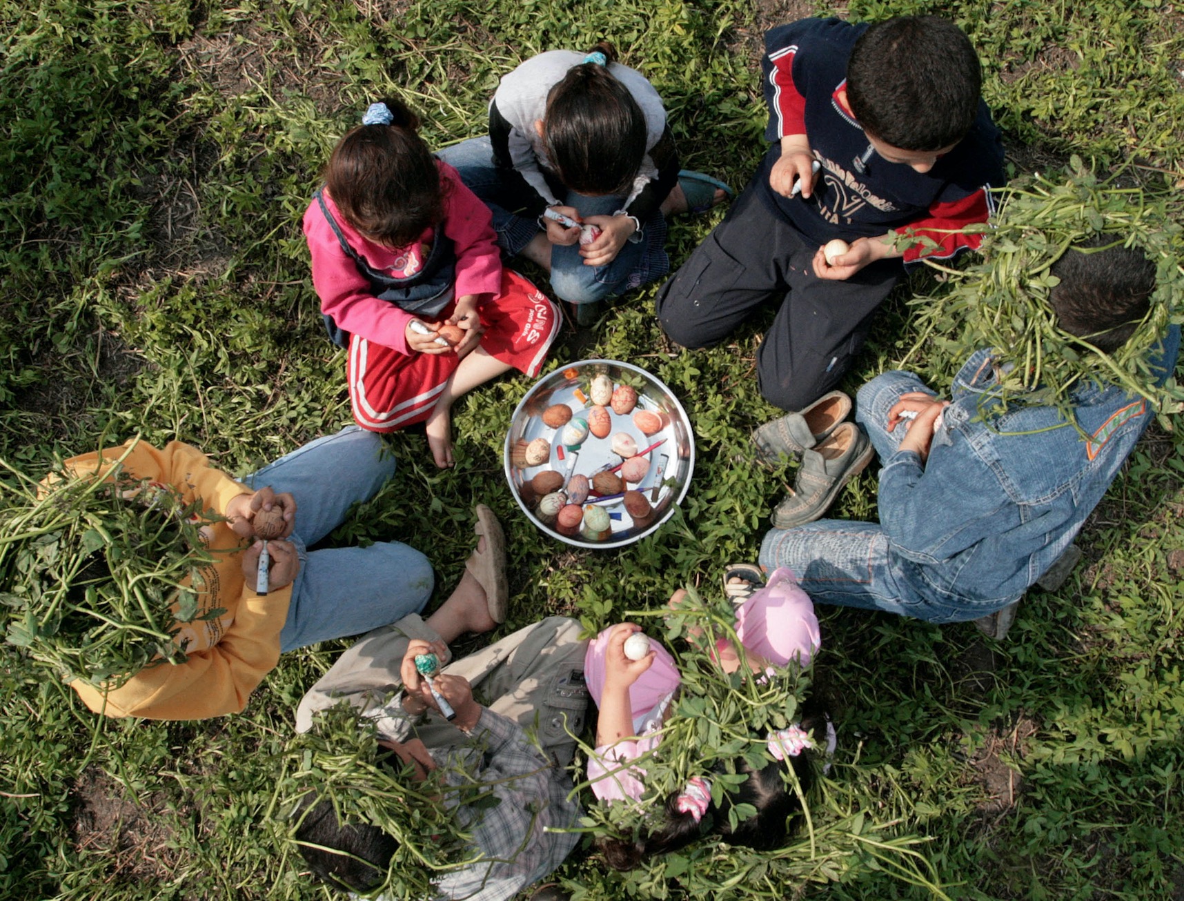 Des enfants décorent des œufs à Mansourah, ville sur le delta du Nil, pour symboliser le renouveau (AFP)