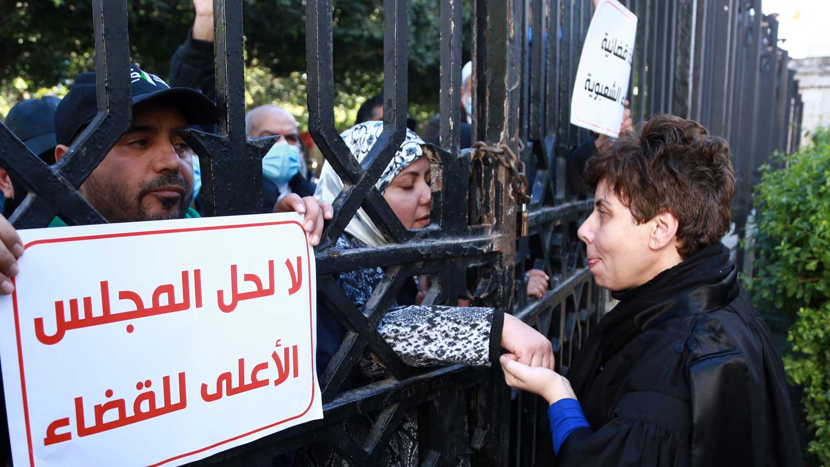 unisian civilians join a protest by judges against the dissolution of the Supreme Judicial Council (CSM) by the Tunisian president, in Tunis on February 10, 2022. 