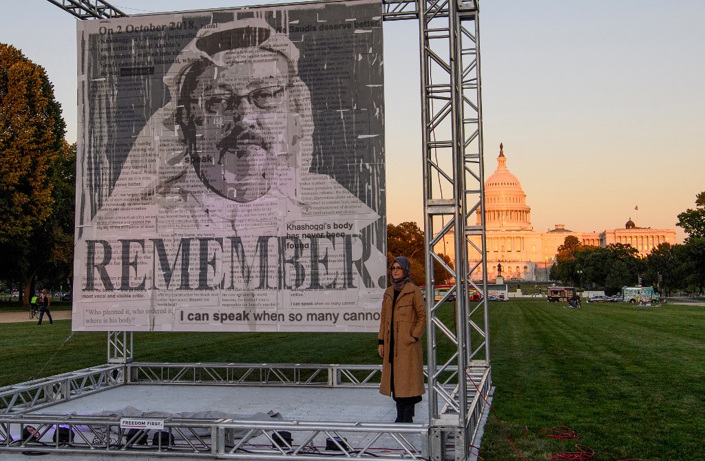 Hatice Cengiz, fiancee of murdered Saudi journalist and dissident Jamal Khashoggi, poses next to a portrait of him after unveiling it on the National Mall in Washington, DC, on 1 October 2021 (AFP)