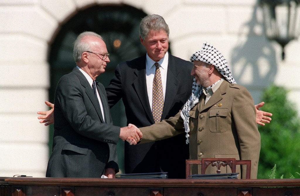 Yasser Arafat (R) and Yitzahk Rabin (L) shake hands watched by US President Bill Clinton on 13 September 1993 at the White House after the signing of the Oslo accords (AFP)